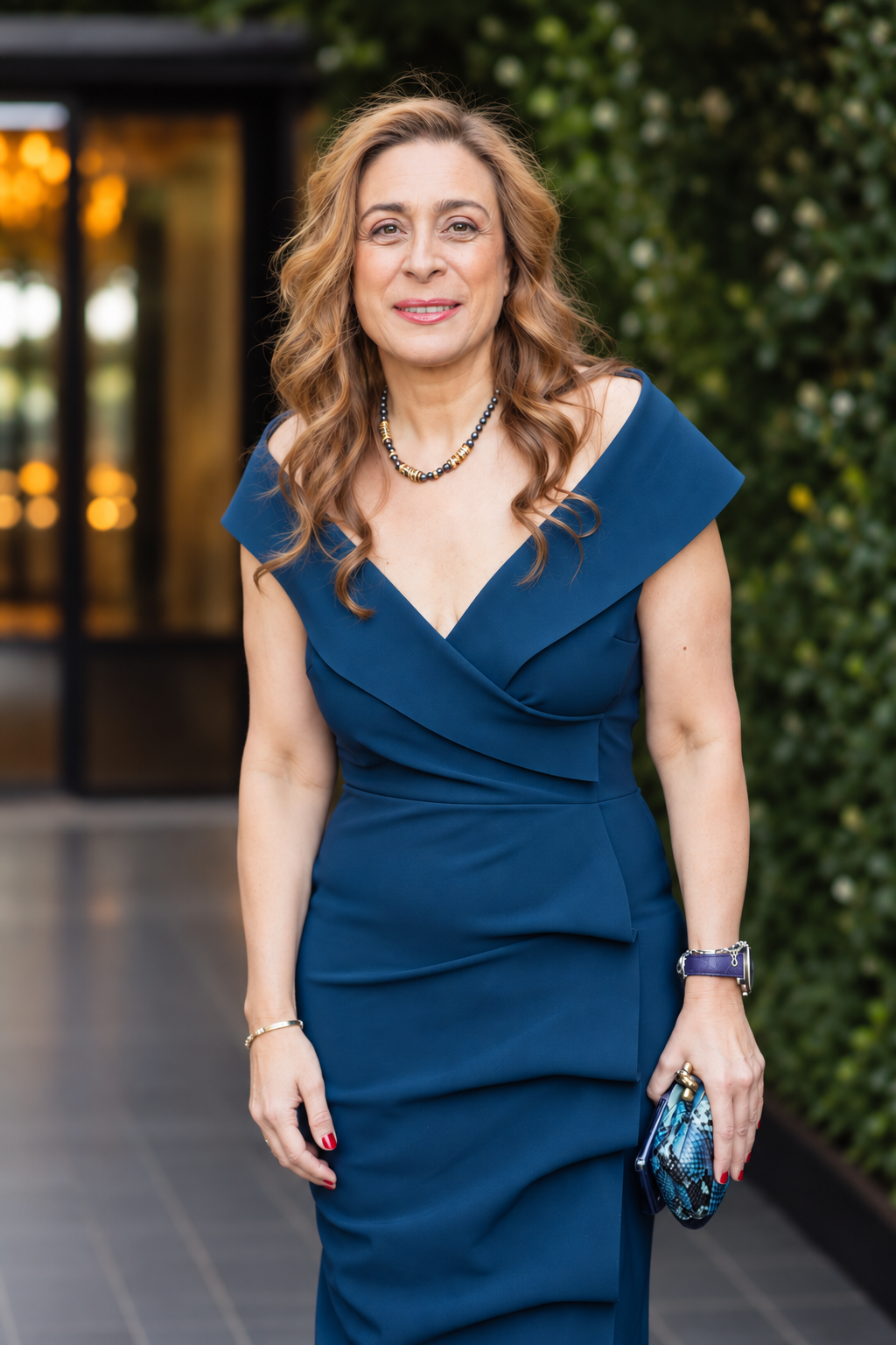 Kris Botros standing outside with a blue dress
