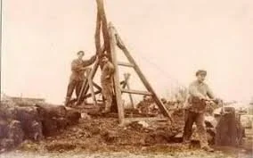 Groupe d'hommes utilisant un grand treillis en bois lors d'un chantier de construction