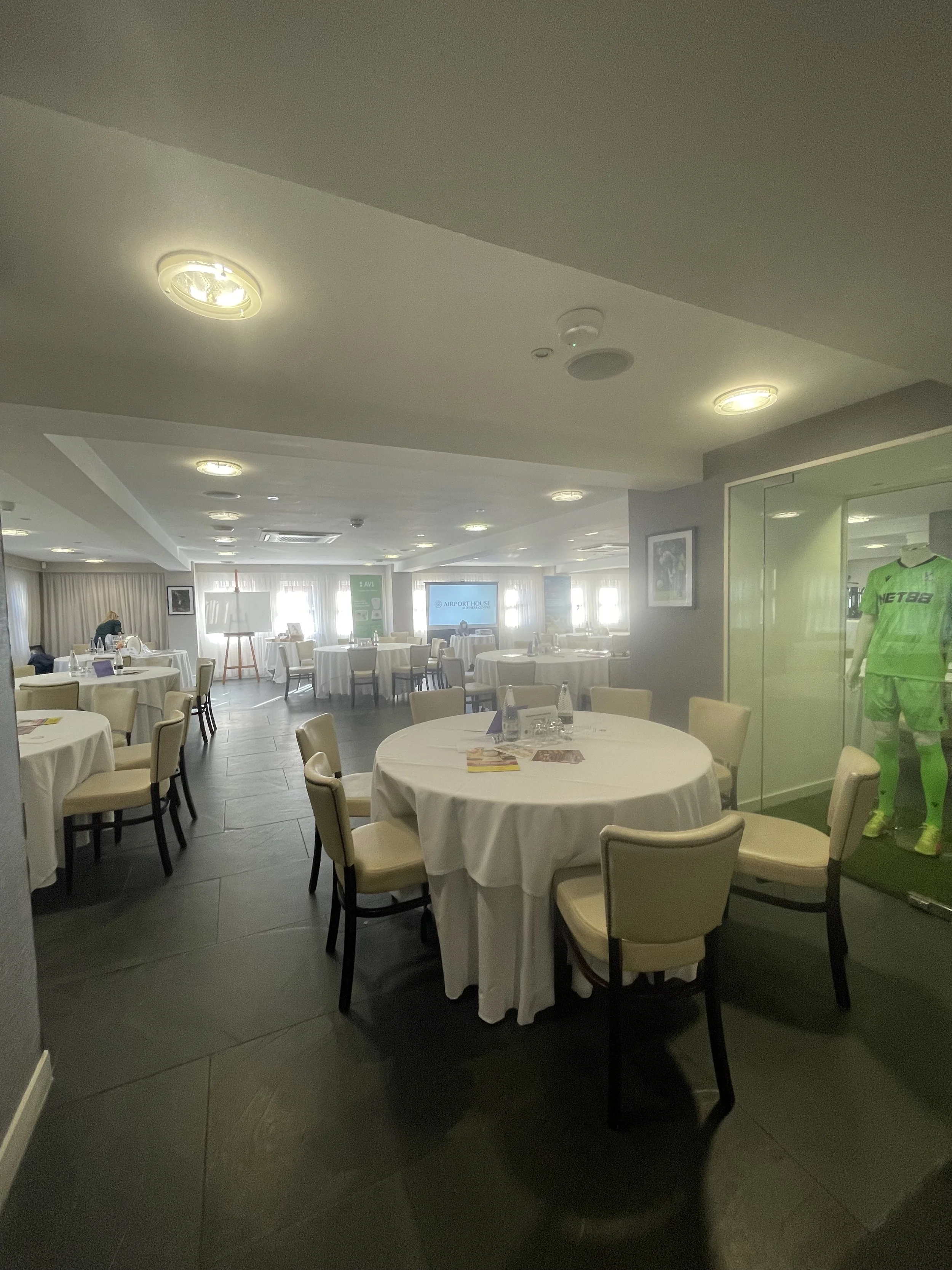 Function room at selhurst park stadium at charity evening. In front of the window at the far end of the room is the easel and board used by Zoe Parker Illustration to create a graphic recording of the event.