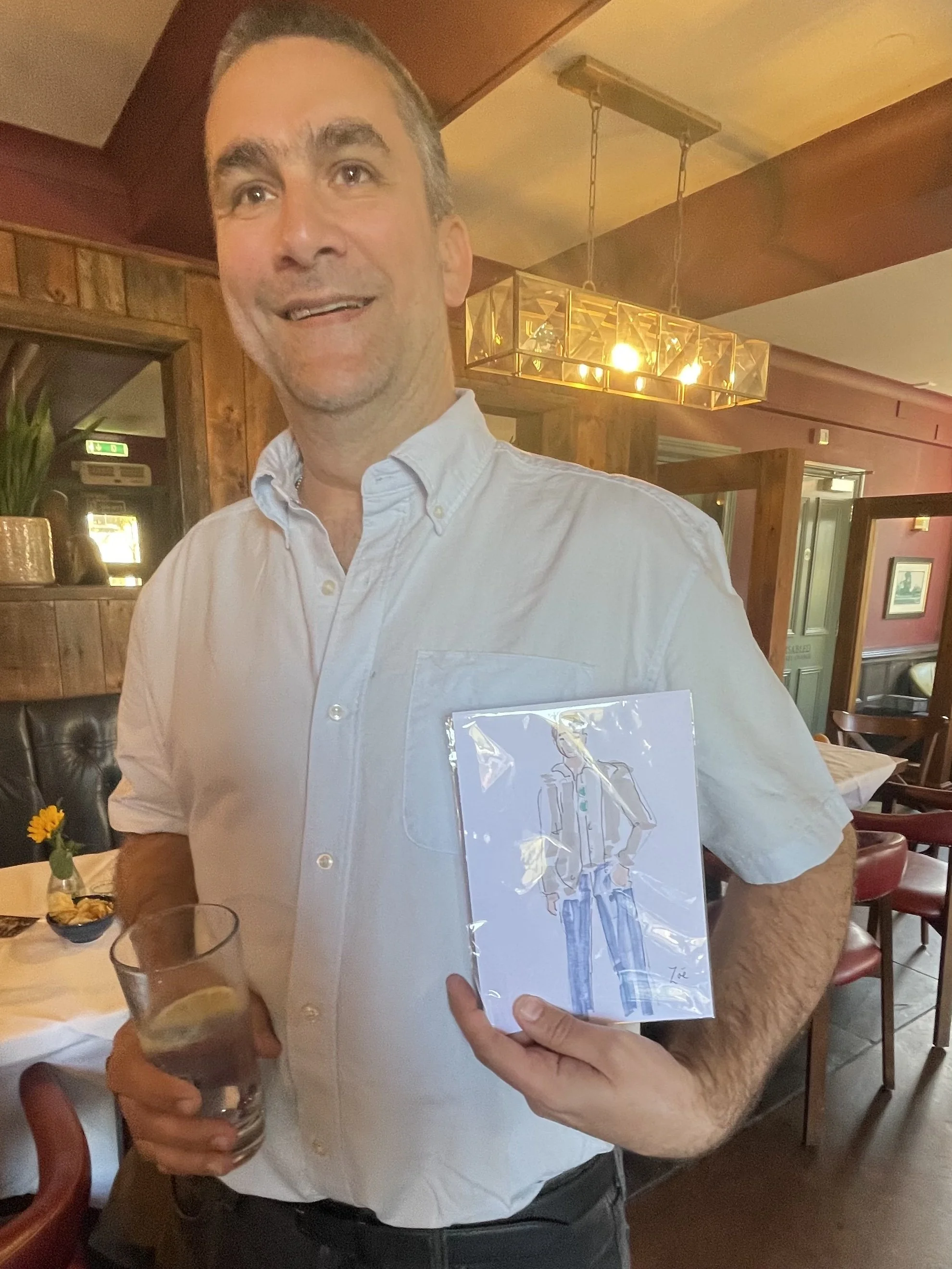 Happy male customer holds live illustration by Zoe Parker illustration at event by Bells Accountants.JPEG