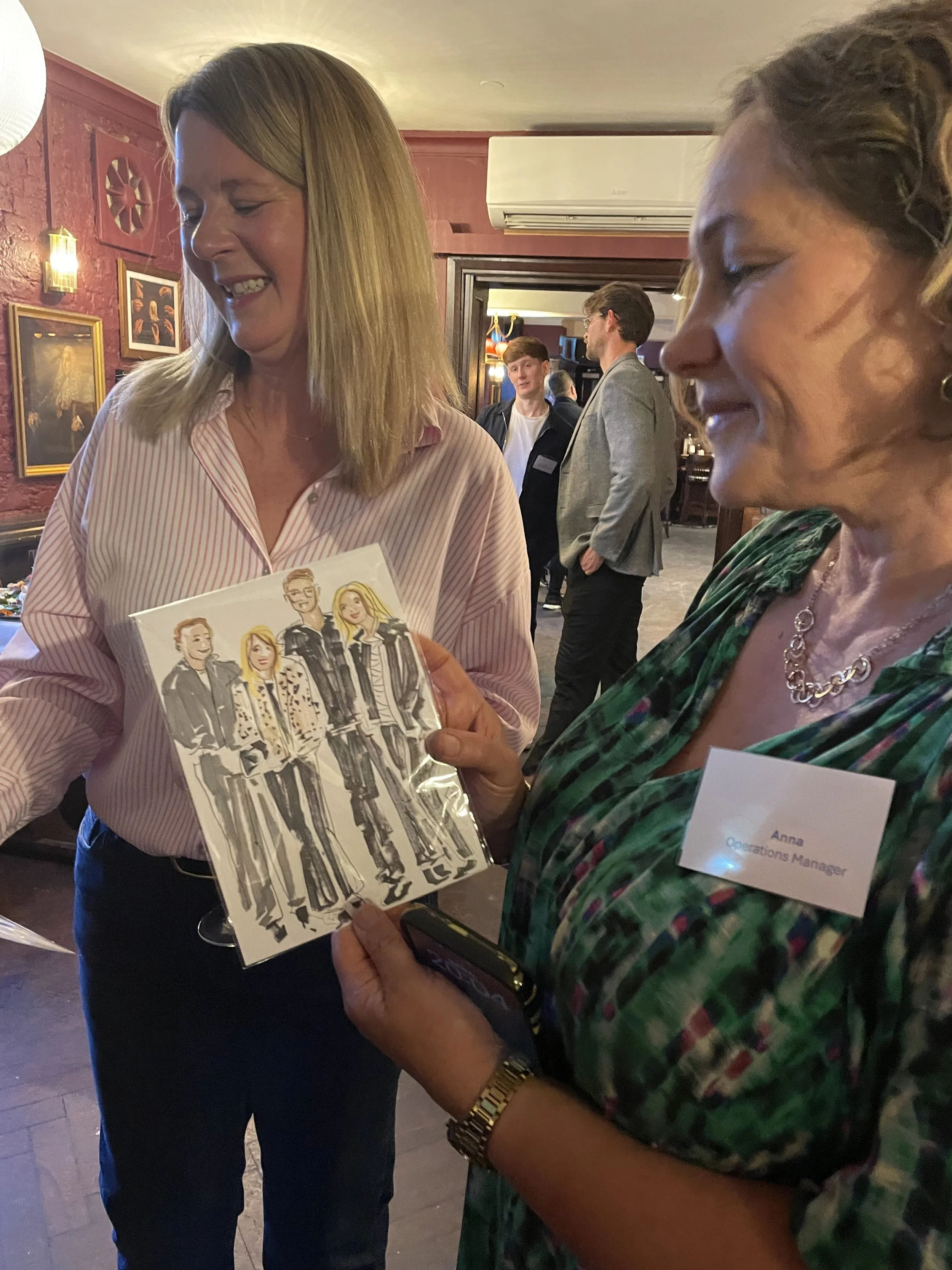 Happy customer looks at live illustration by Zoe Parker illustration at event by Bells Accountants.JPEG
