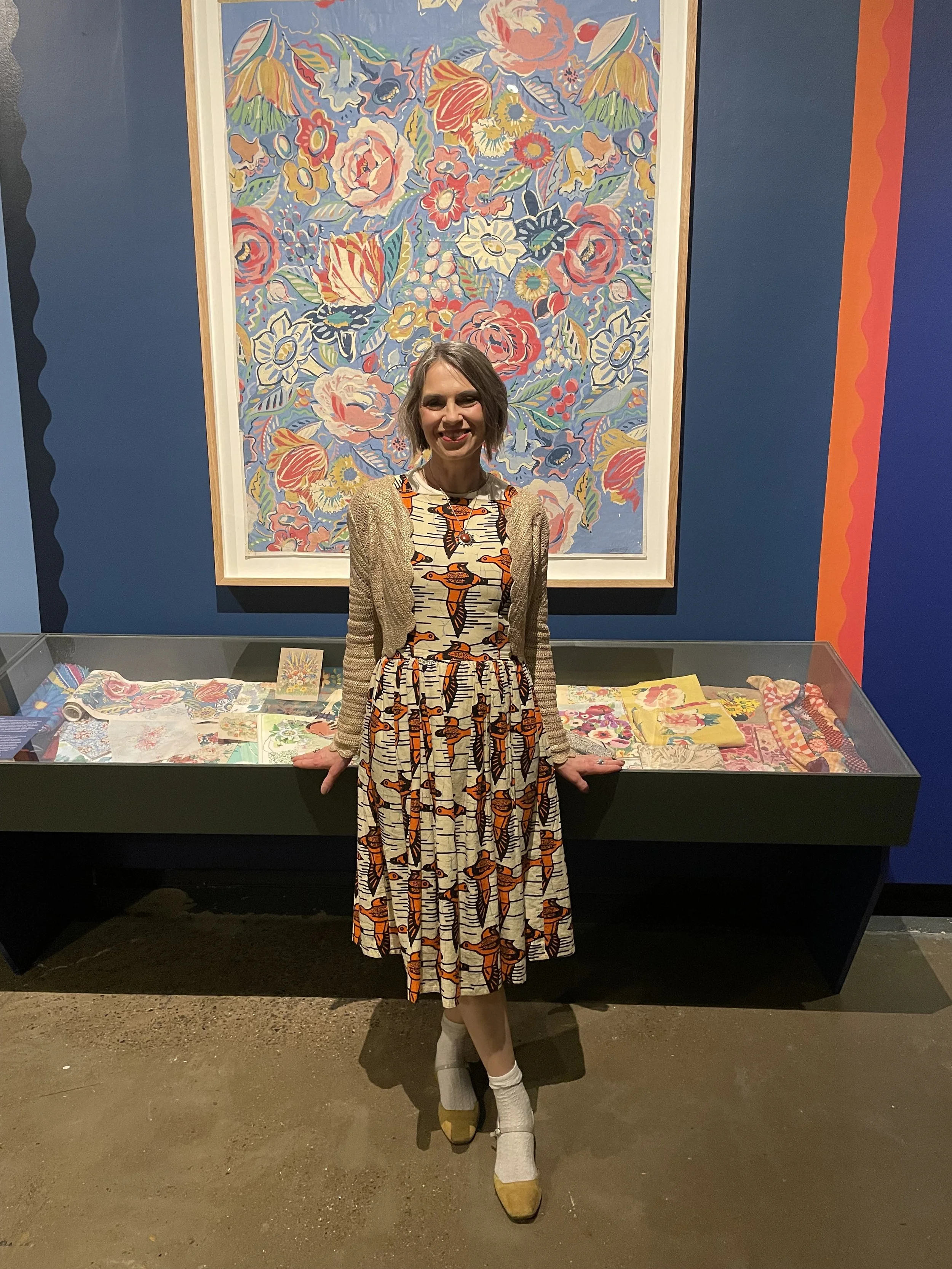 Zoe Parker Illustration standing in front of a floral print painted by Collier Campbell.JPEG