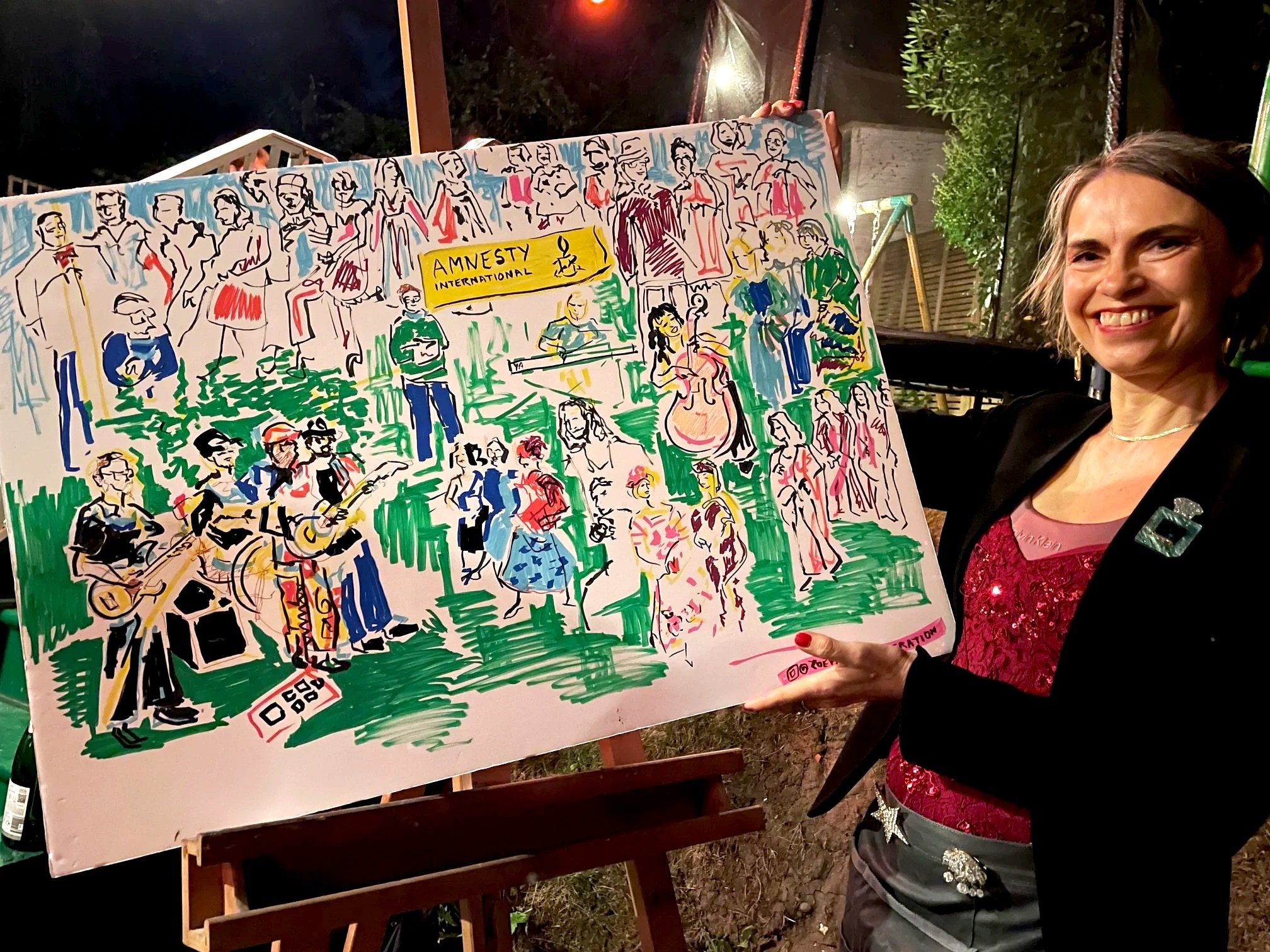 Zoe Parker Illustration holding her Live Illustration drawn at a fundraising garden party for Amnesty International