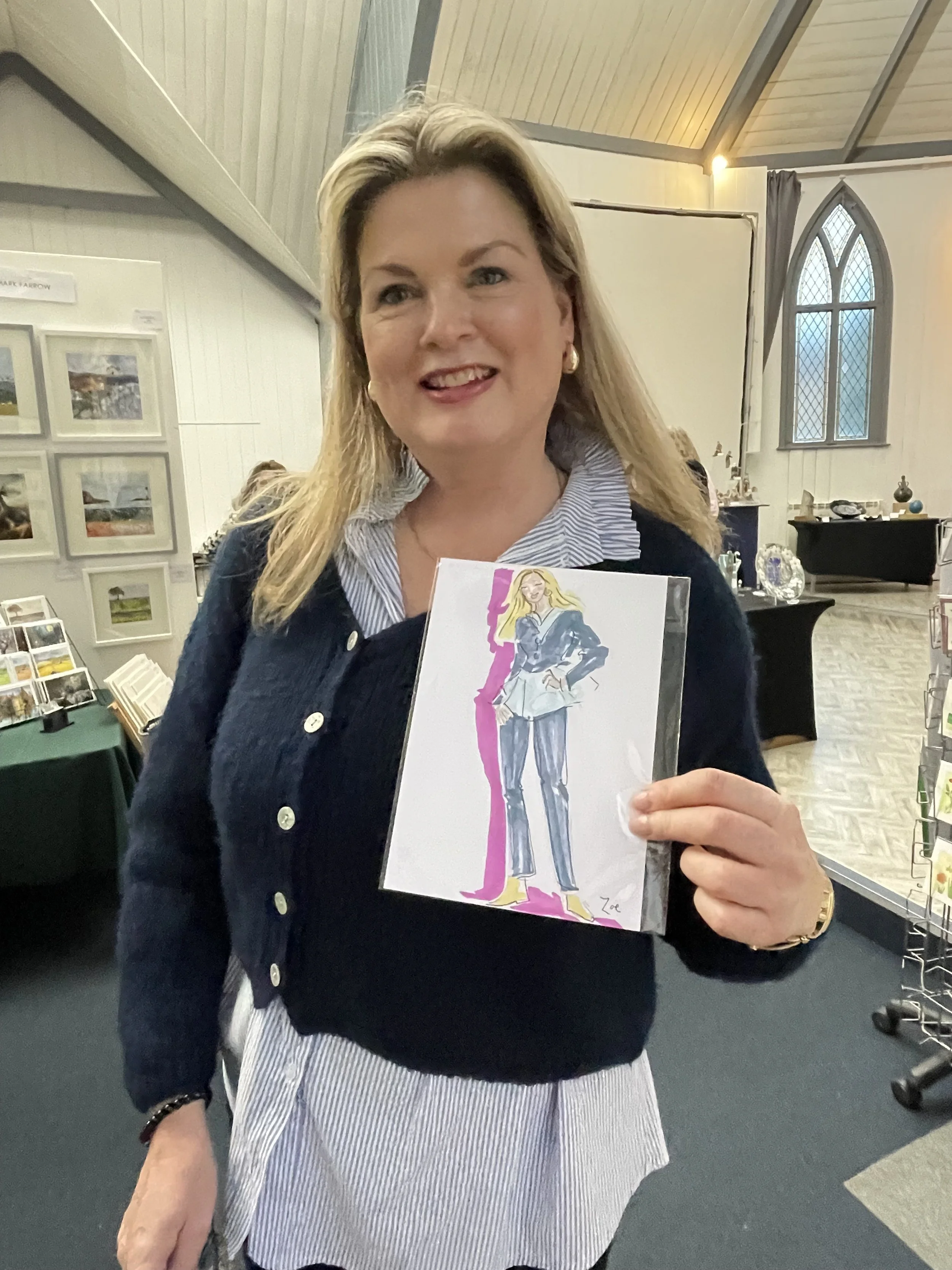 Happy female customer dressed in blue holding live portrait by Zoe Parker Illustration