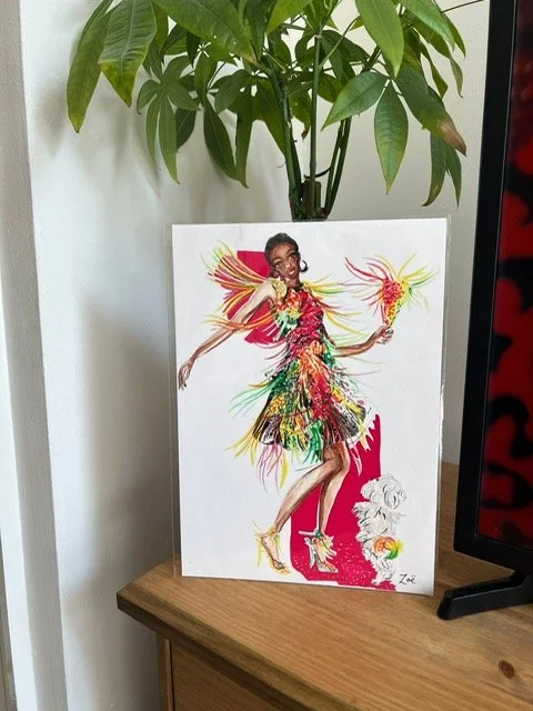 A photograph of a giclee print of a fashion illustration by Zoe Parker Illustration. The print features a woman in a colourful outfit dancing with a dog. The background is blocks of pink and the woman's dress has tassells.