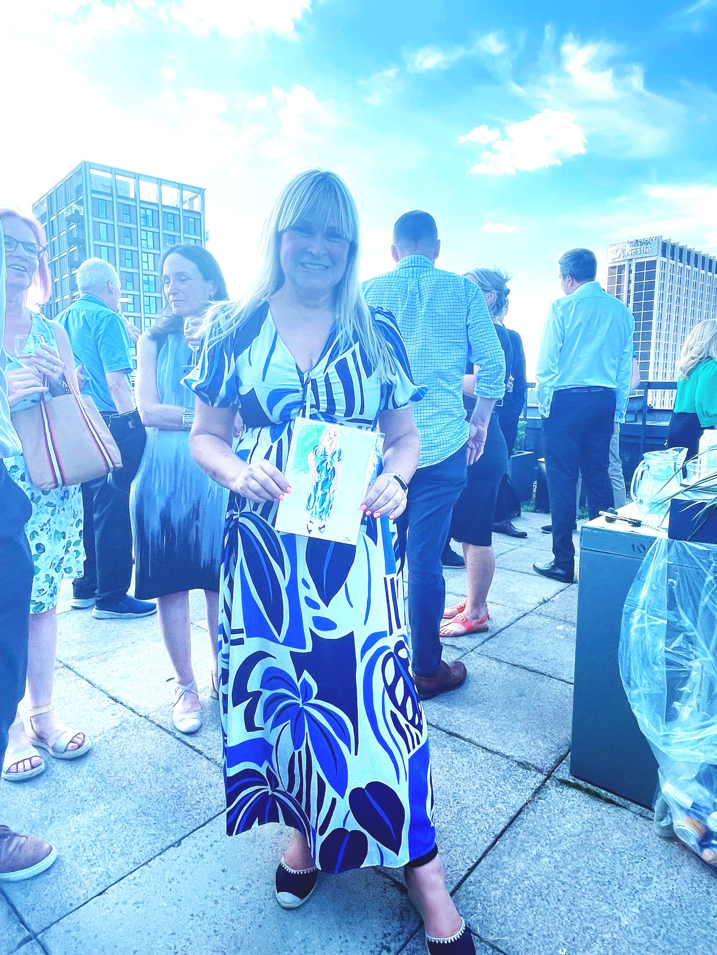 Happy customer holding her illustration at a live event for NatWest bank