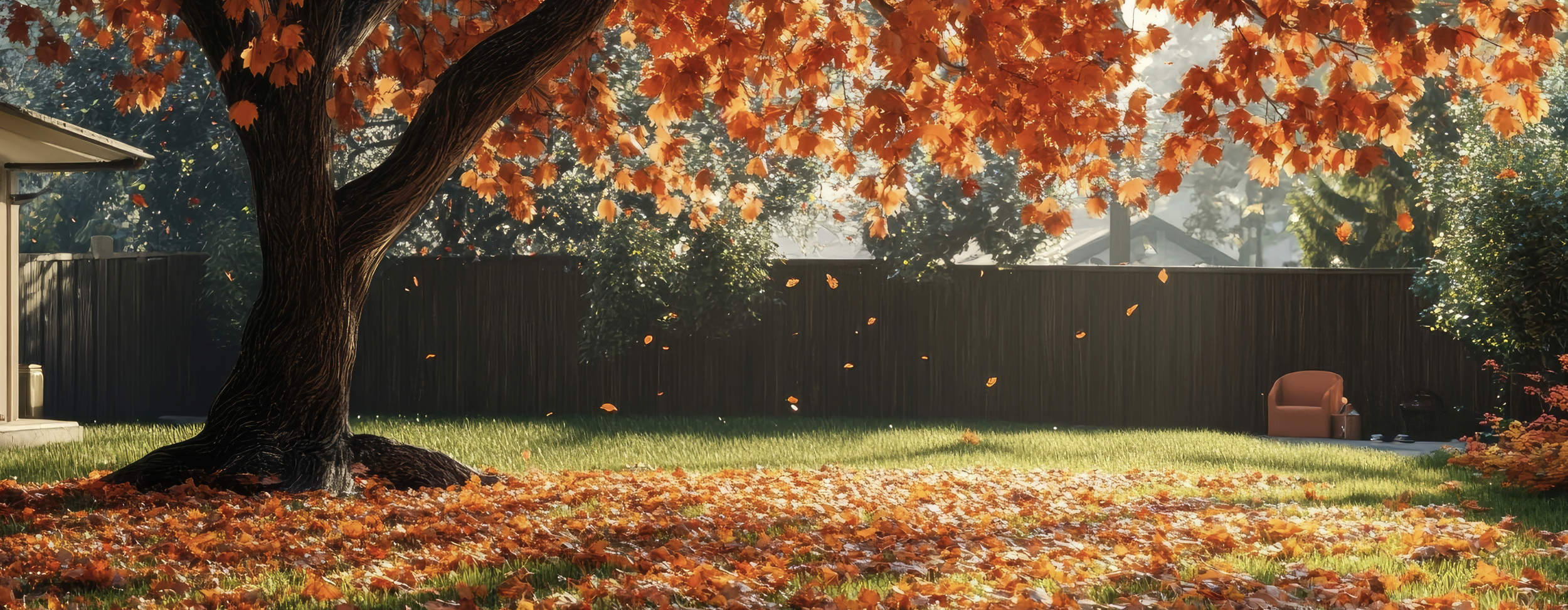 Orange leaves falling from a tree over green grass.