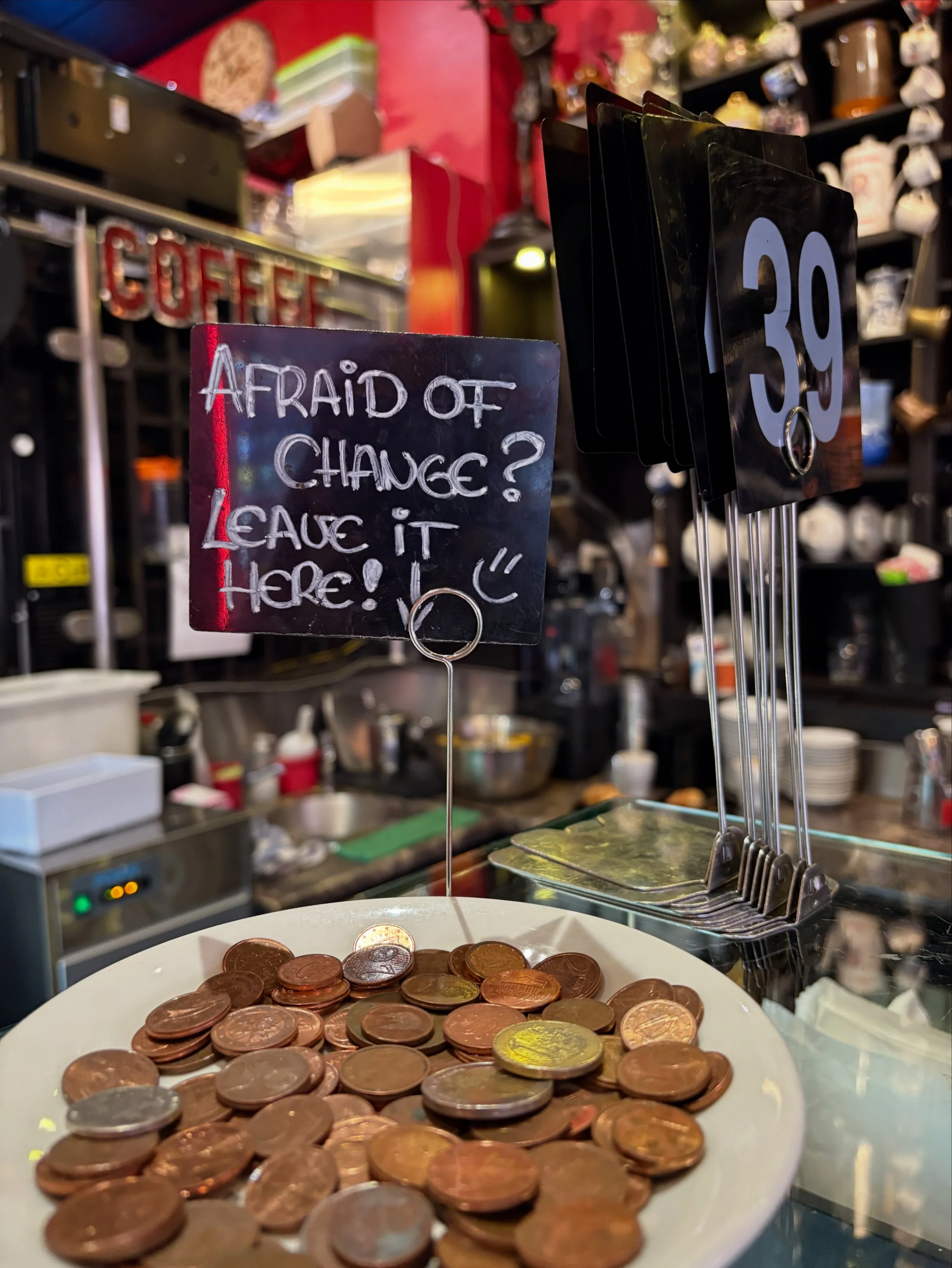 A sign saying "Afraid of change? Leave it here" at a leave a penny dish