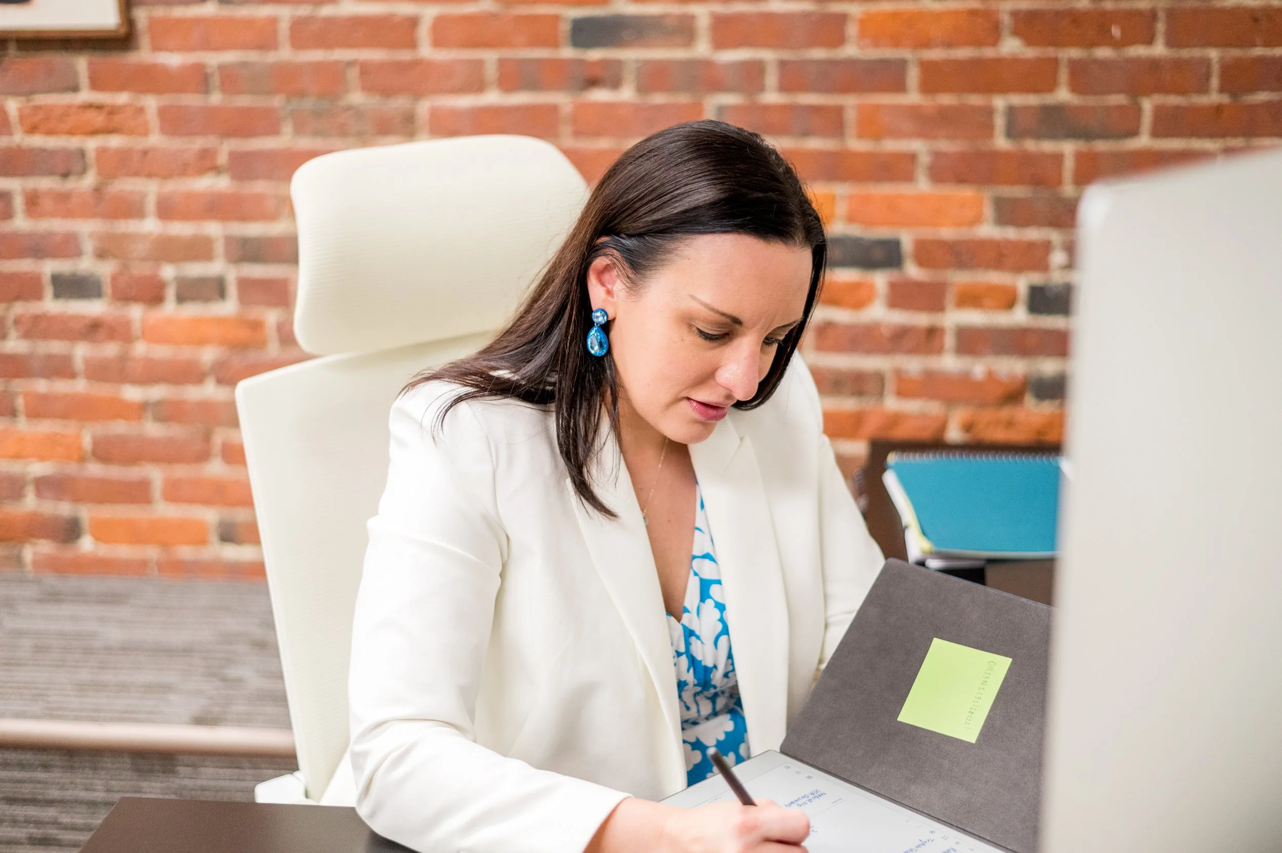 Michaele at a desk writing in her planner