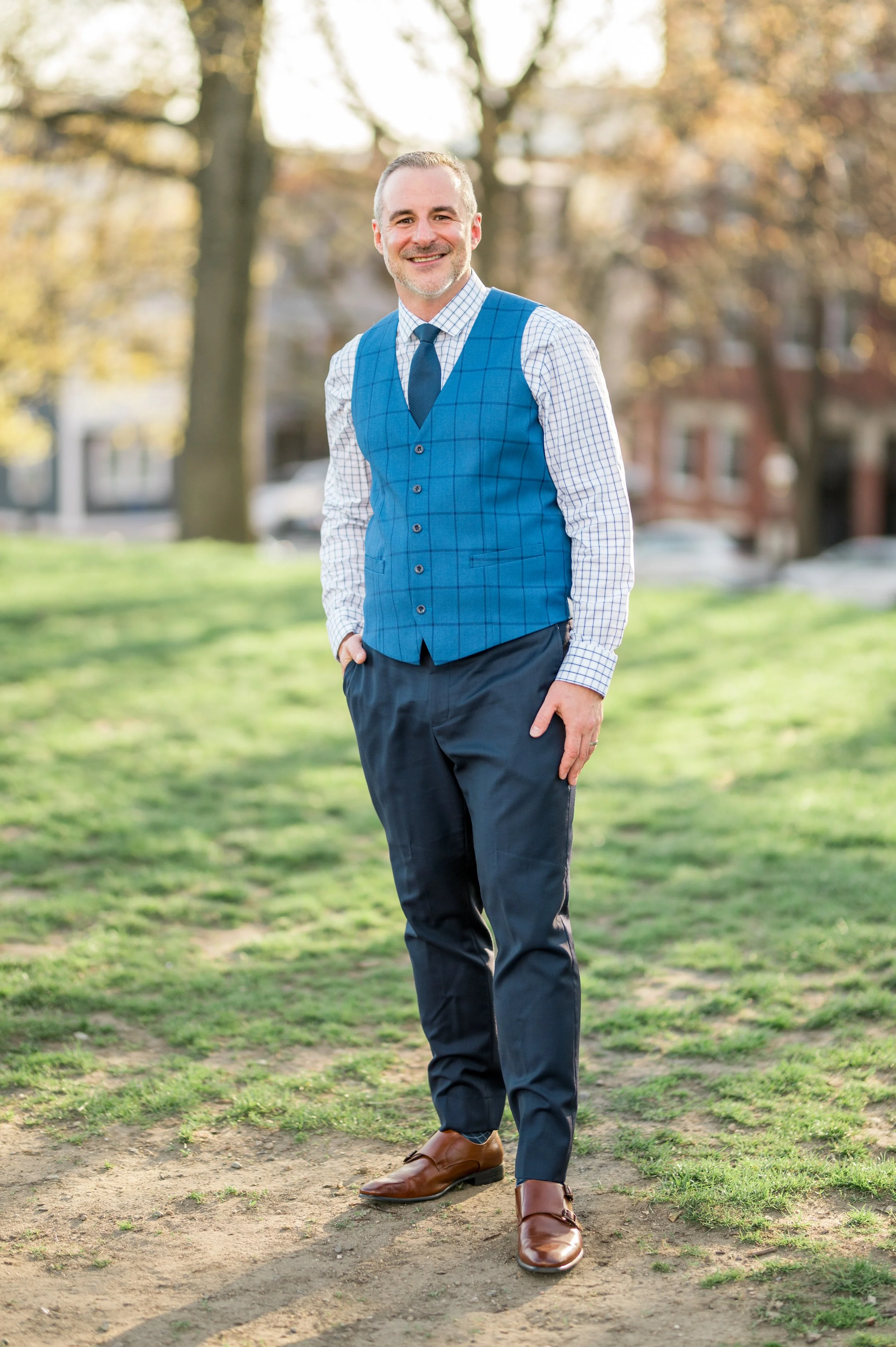 Dan in a park wearing a vest and tie