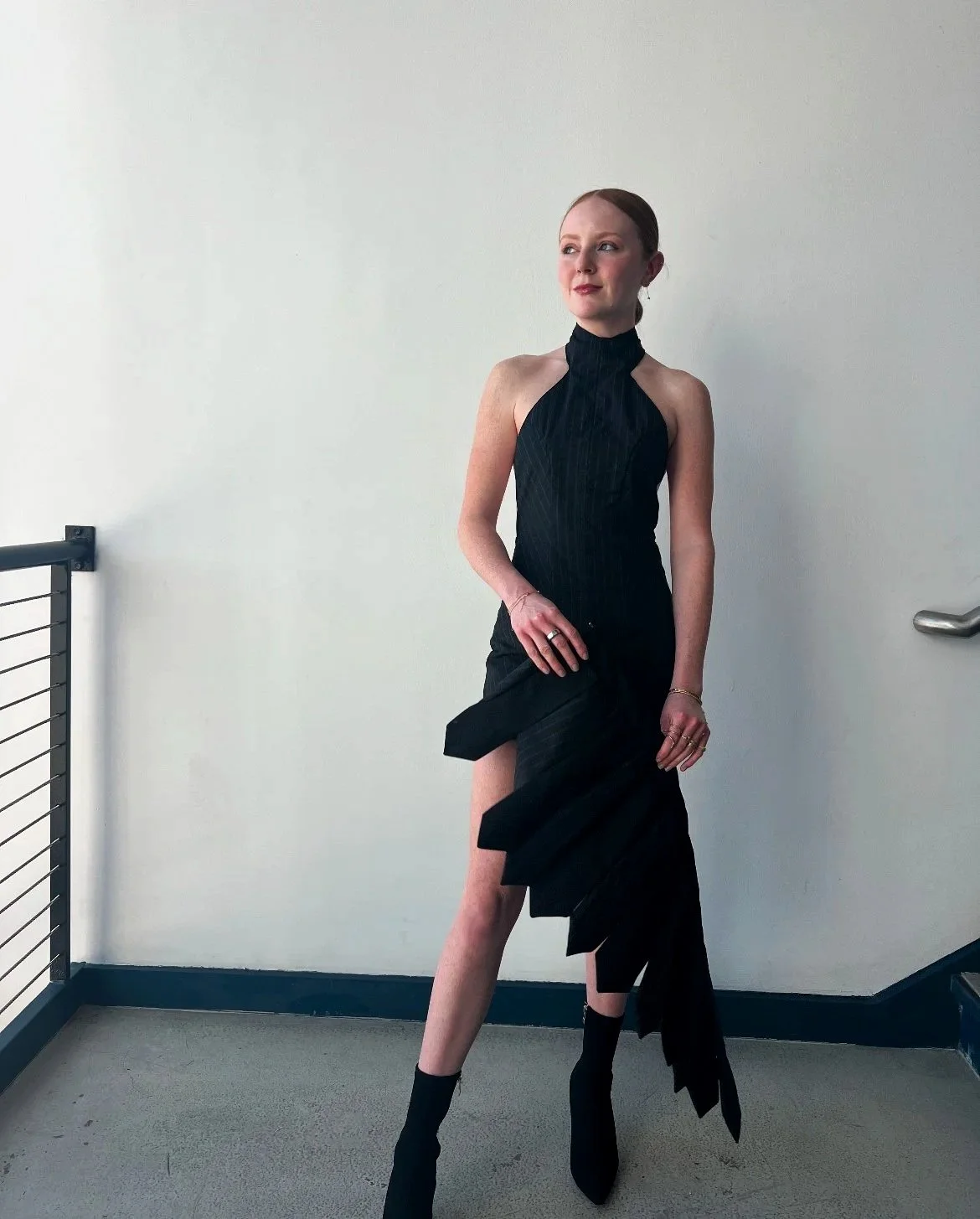 Backless halter neck romper with removable back chain and hook and eye mini skirt. Made with pinstripe wool suiting fabric, gold hook and eye closures, hidden snaps, invisible side zipper, and gold rings.