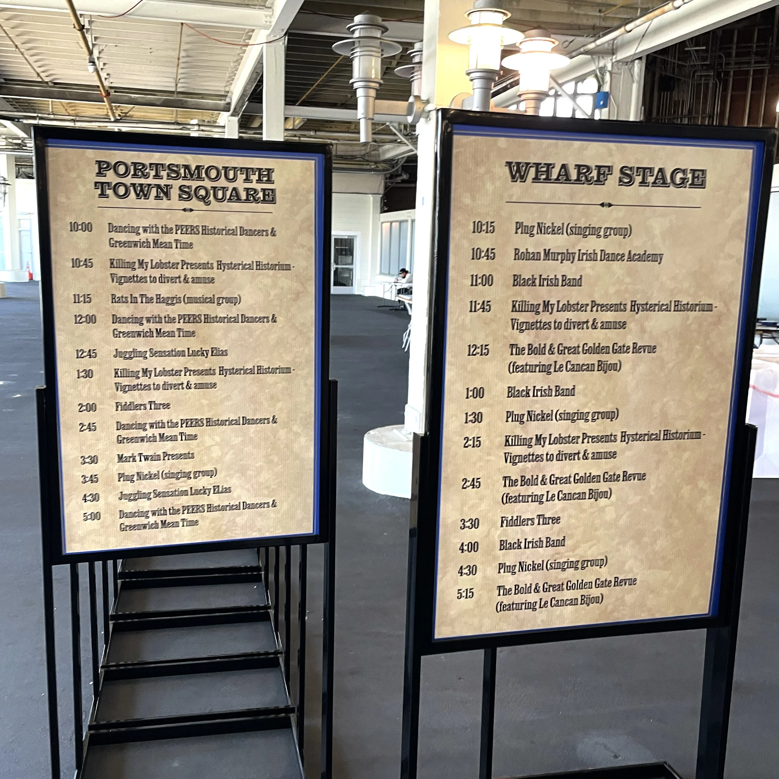 Event schedule boards with listings for Portsmouth Town Square and Wharf Stage, displaying events and times.