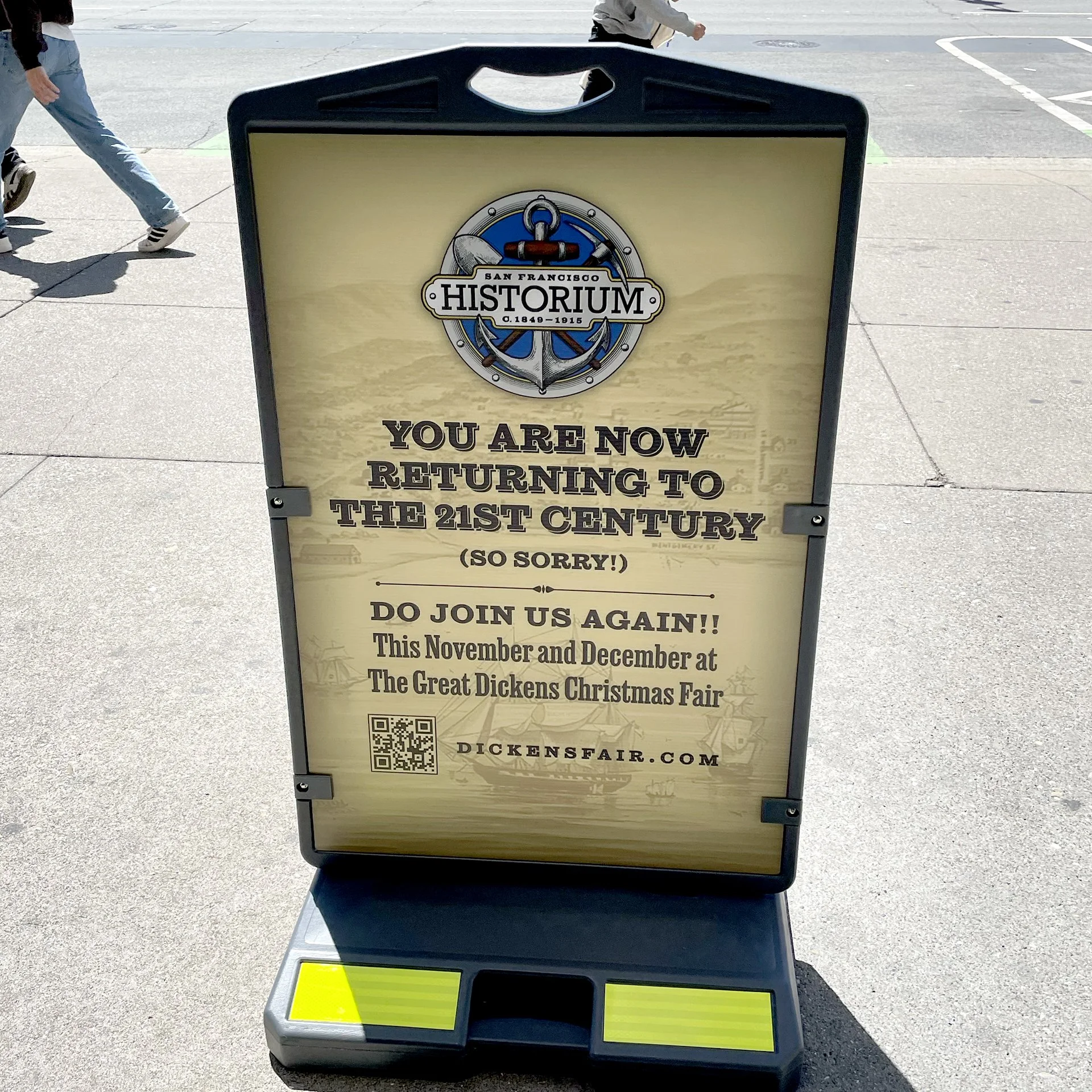 Signboard for San Francisco Historium stating visitors are returning to the 21st century and inviting them to join the event at Dickens Fair, with website URL and QR code at the bottom.