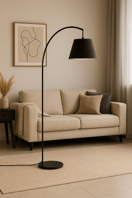 Living room with a beige sofa, black floor lamp, framed abstract art on the wall, a side table with a vase of dried grass, and beige curtains.