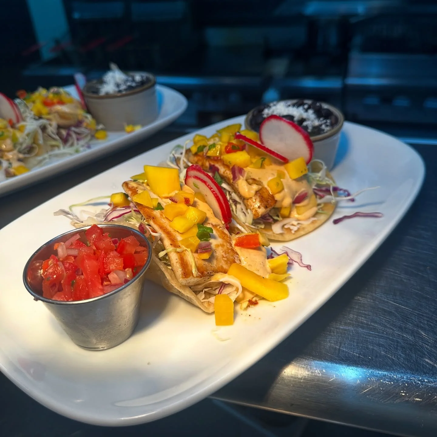 🌊🔥 Fresh off the grill and straight to your taste buds &mdash; our mahi fish tacos bring the heat with chipotle slaw, sweet mango salsa, and pico, all wrapped in warm flour tortillas. One bite, and you&rsquo;re hooked! 🐟🌮
