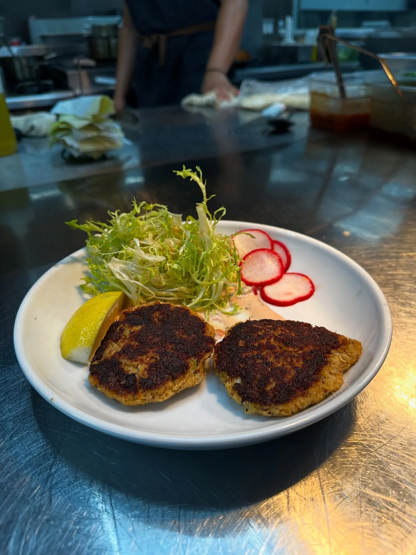 ✨ Golden, crispy, and packed with flavor &mdash; our house-made crab cakes are served fresh with a touch of zest. 🦀🍋 Come taste the seaside on a plate at Seven Seas Bar &amp; Grill! 🌊