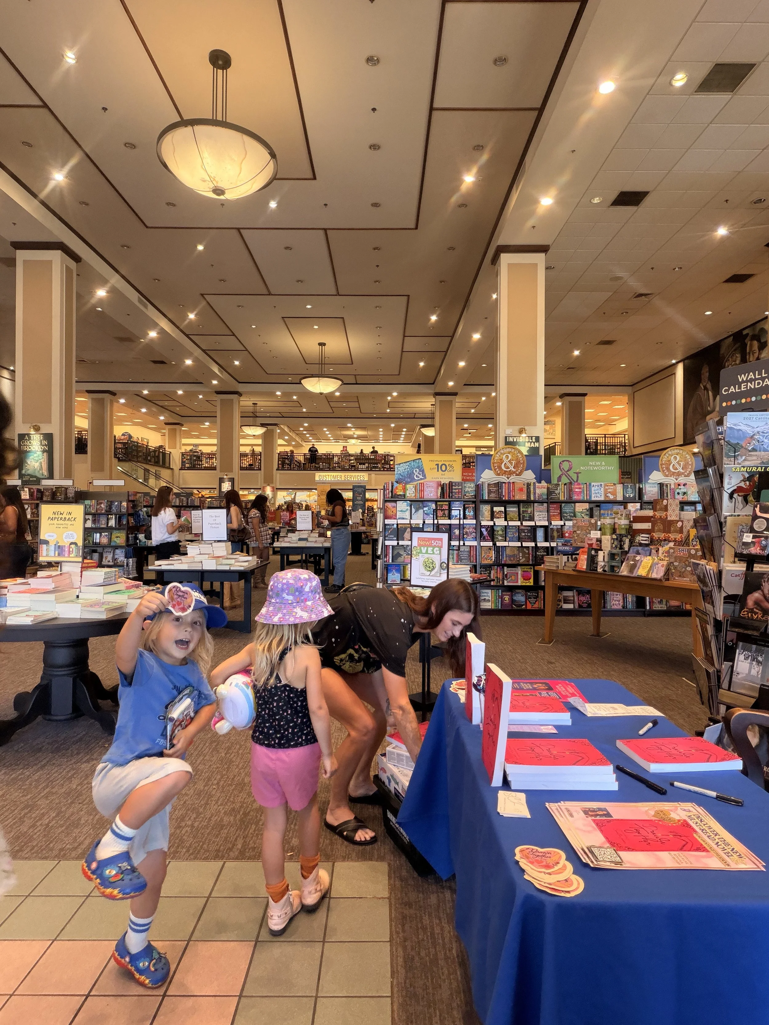 A young reader proudly posing with a Samantha Zamora butterfly sticker after visiting her Barnes & Noble book signing at The Promenade at Westlake.