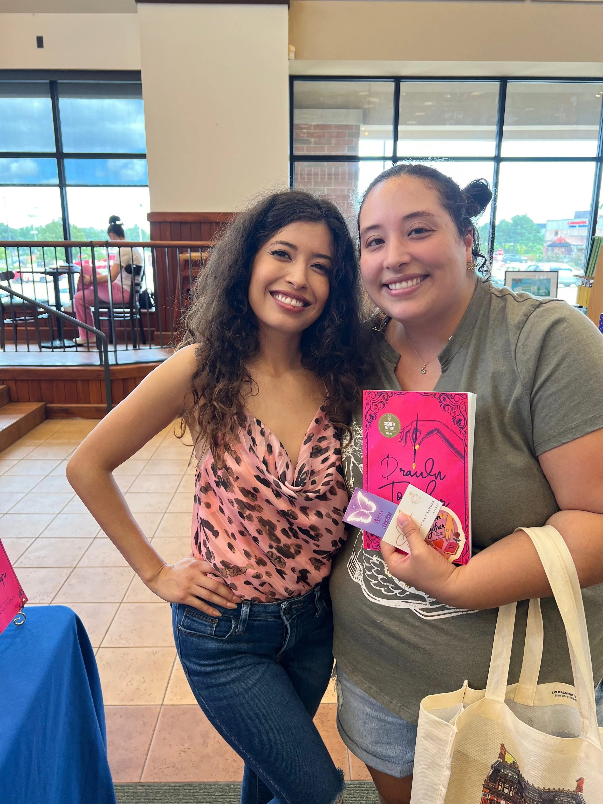 Reader with a signed copy of Drawn Together at Samantha Zamora's Des Moines book signing.