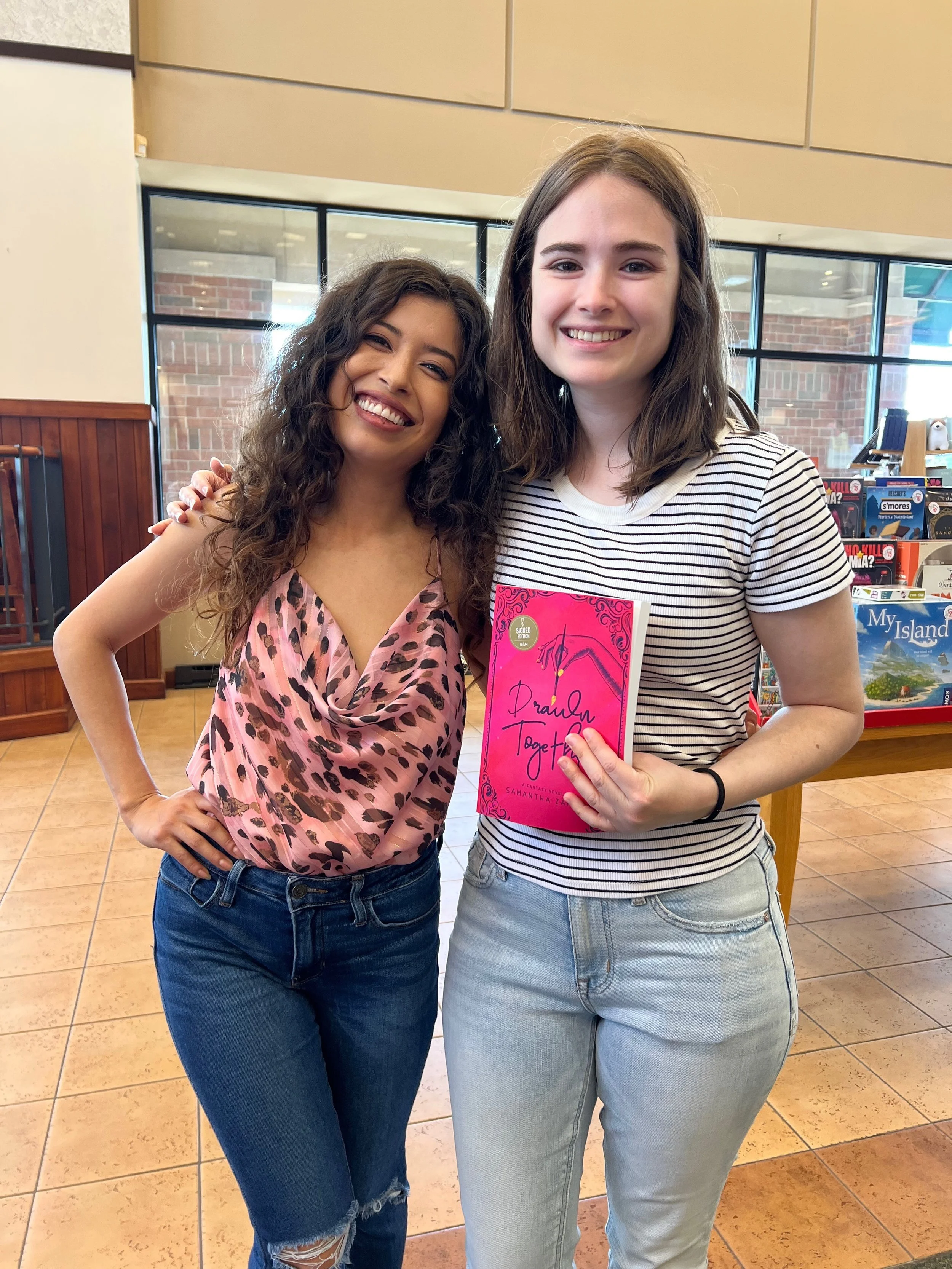 Reader with a signed copy of Drawn Together at Samantha Zamora's Des Moines book signing.