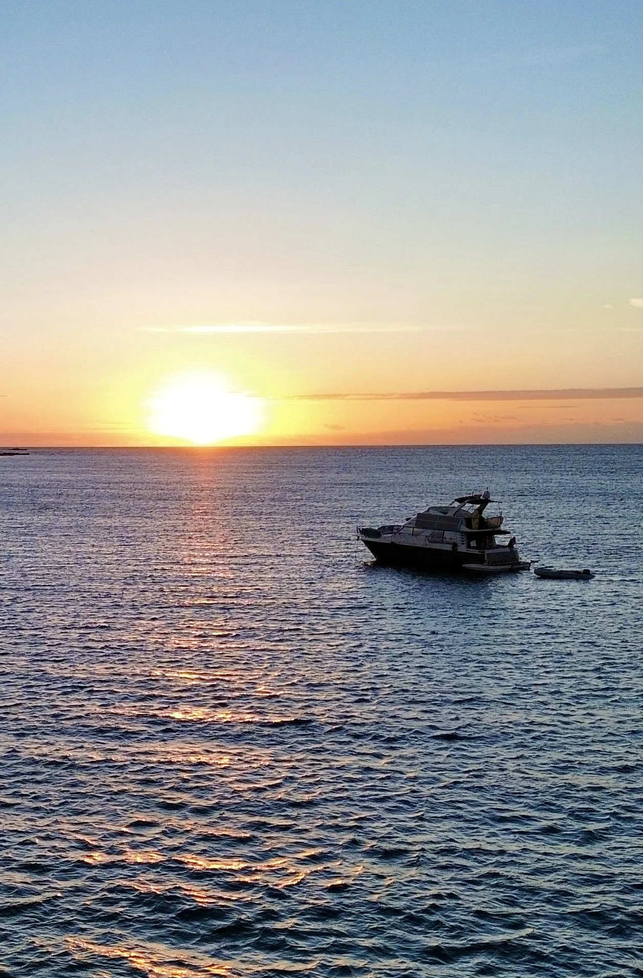 Our Carver 450 Pilothouse during sunset with a vibrant sun reflecting on the water.