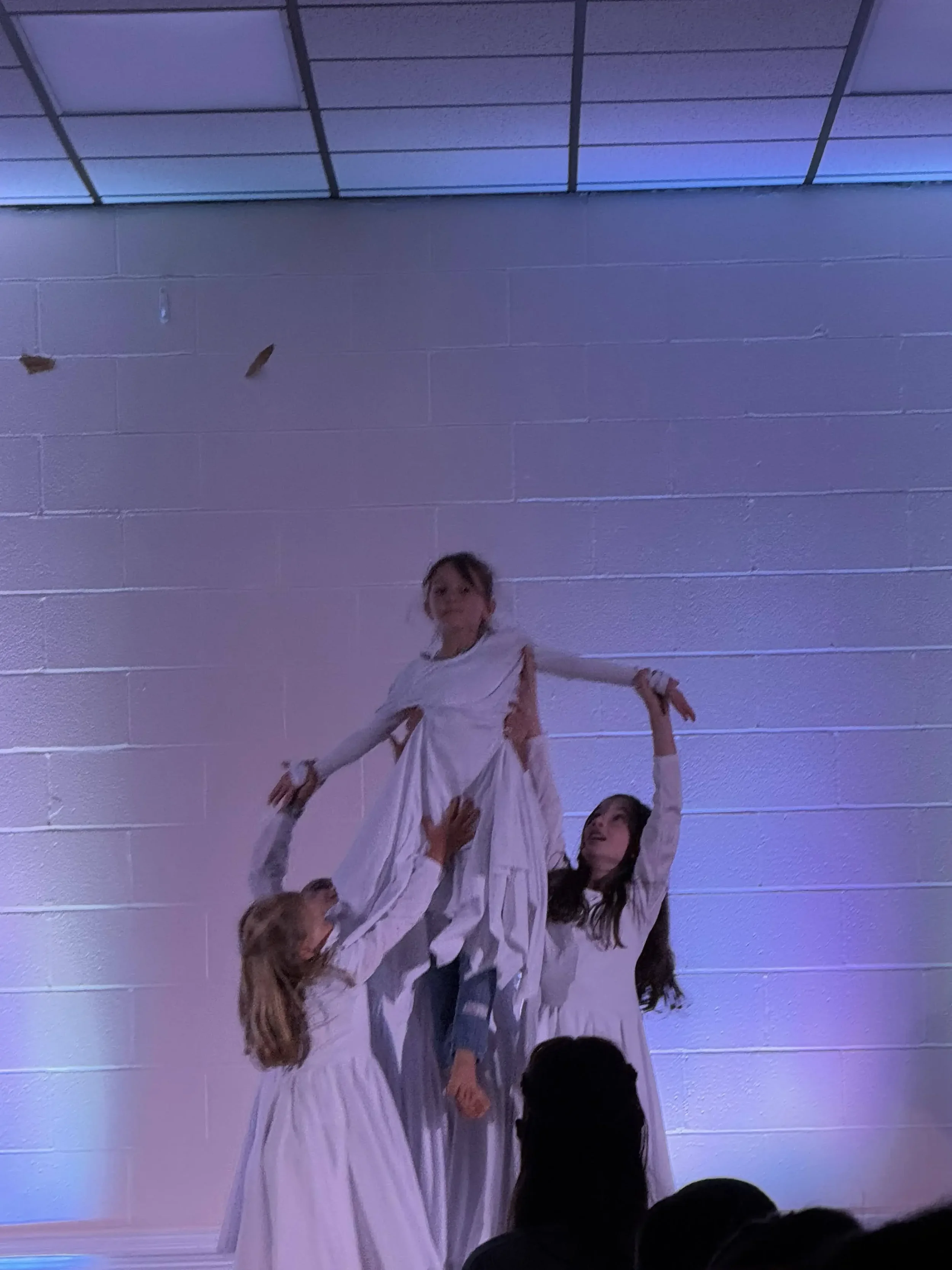  Several dancers lift another dancer into the air as part of a choreographed worship performance. 