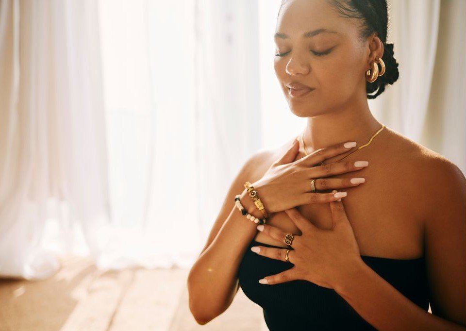 Young lady with both hands on chest, eyes closed.