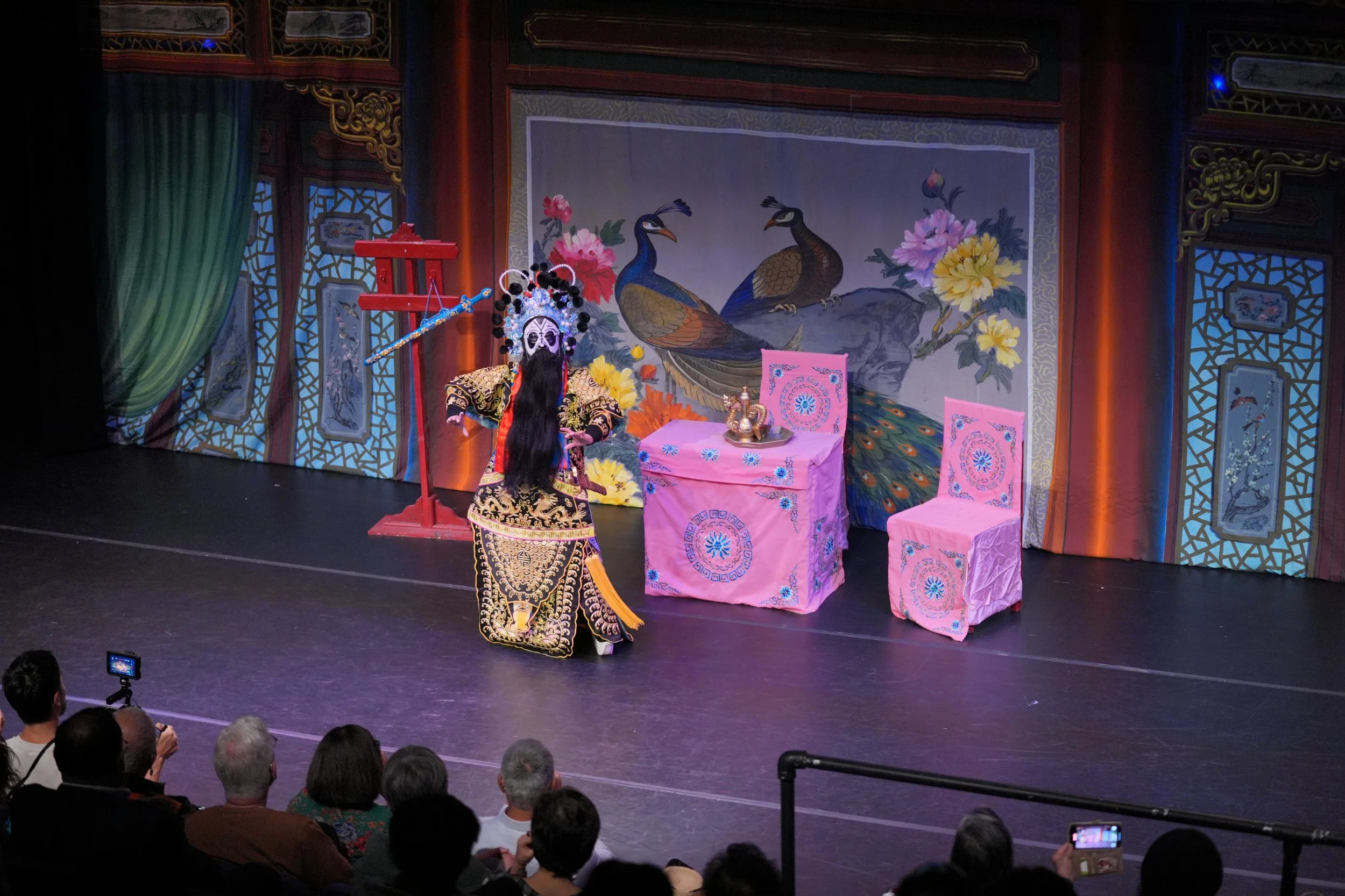 A performer with full costume and face paint posing on stage