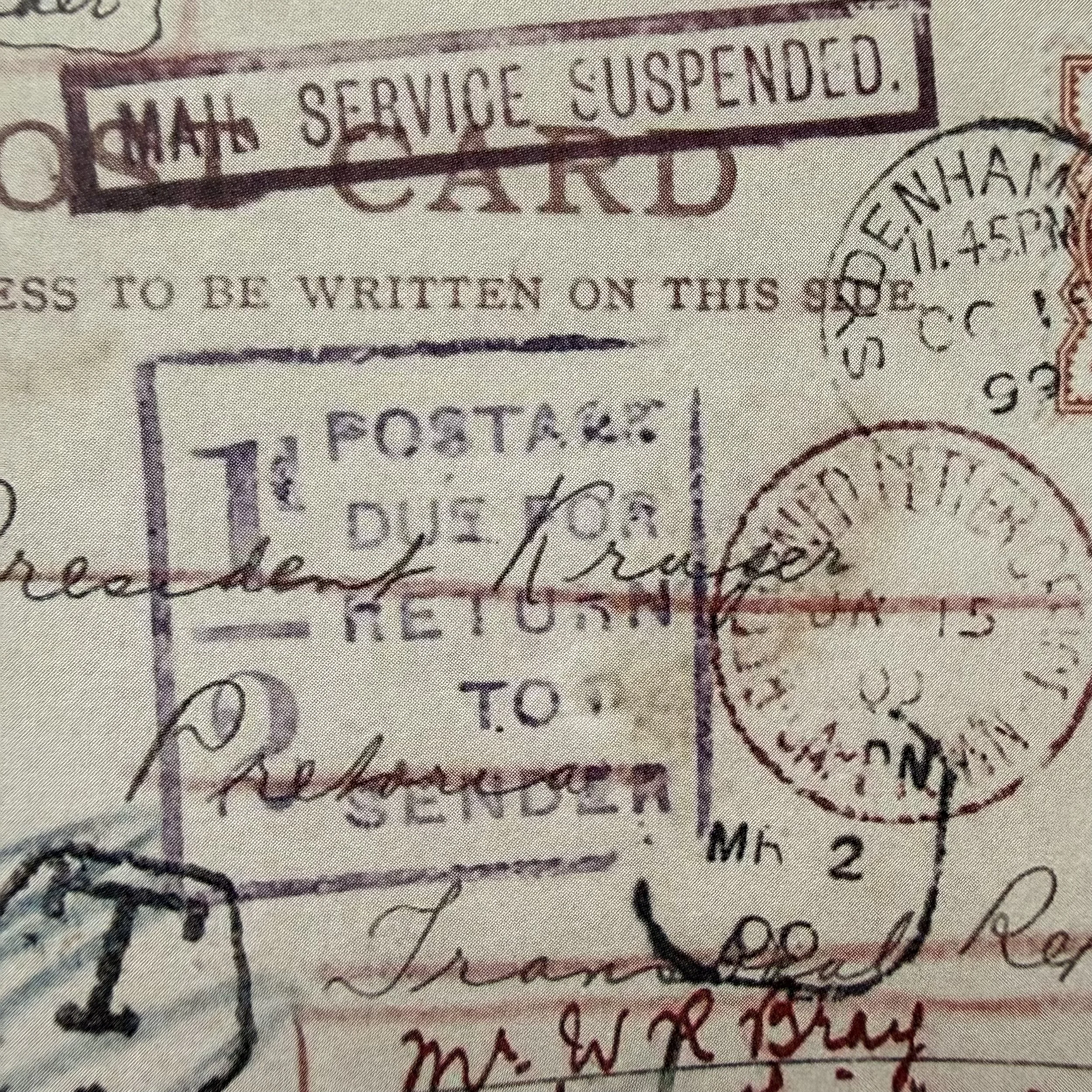 Close-up of a postal service stamp with the words 'Official Service Suspended' and a circular cancellation mark.