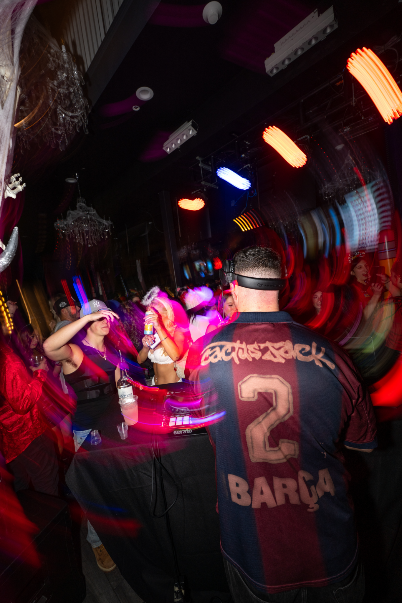 DJ behind DJ booth with strobe lights and LED lights at a long island bar