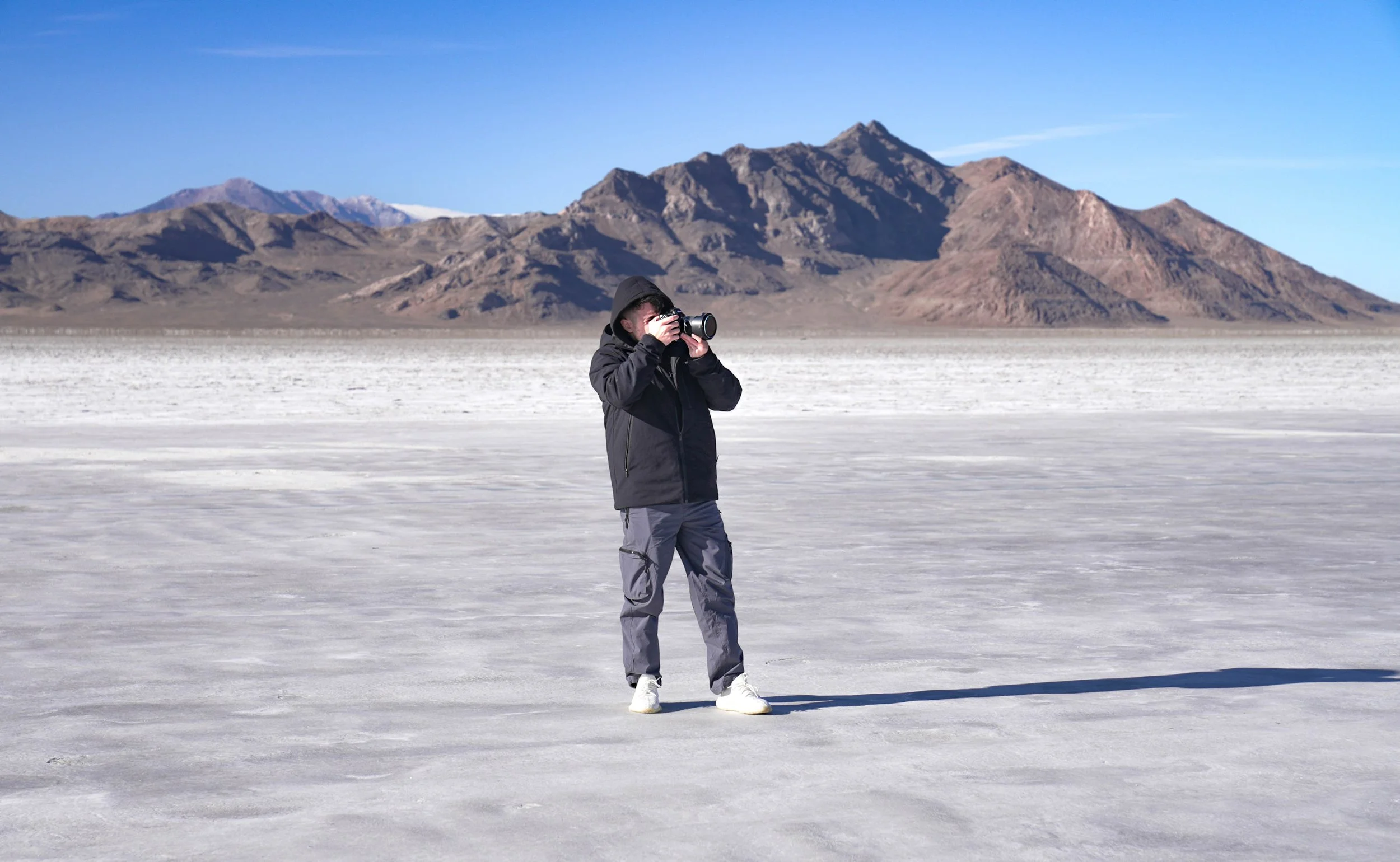 photographer in front of mountains on the Bonneville salt flats of Utah