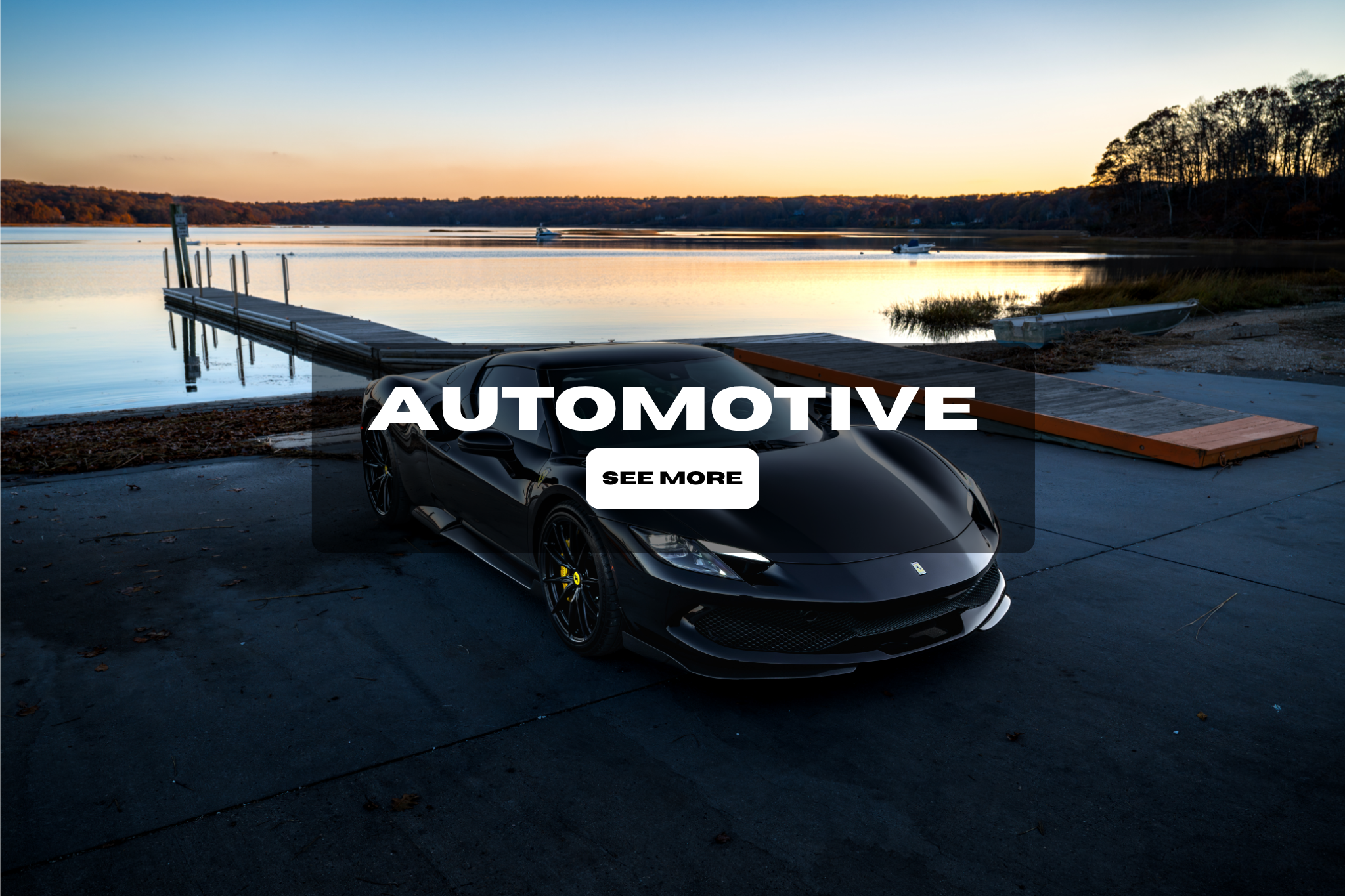 Black sports car parked near a lake at sunset with a dock and boat in the background, overlaid with text 'Automotive' and a 'See More' button.