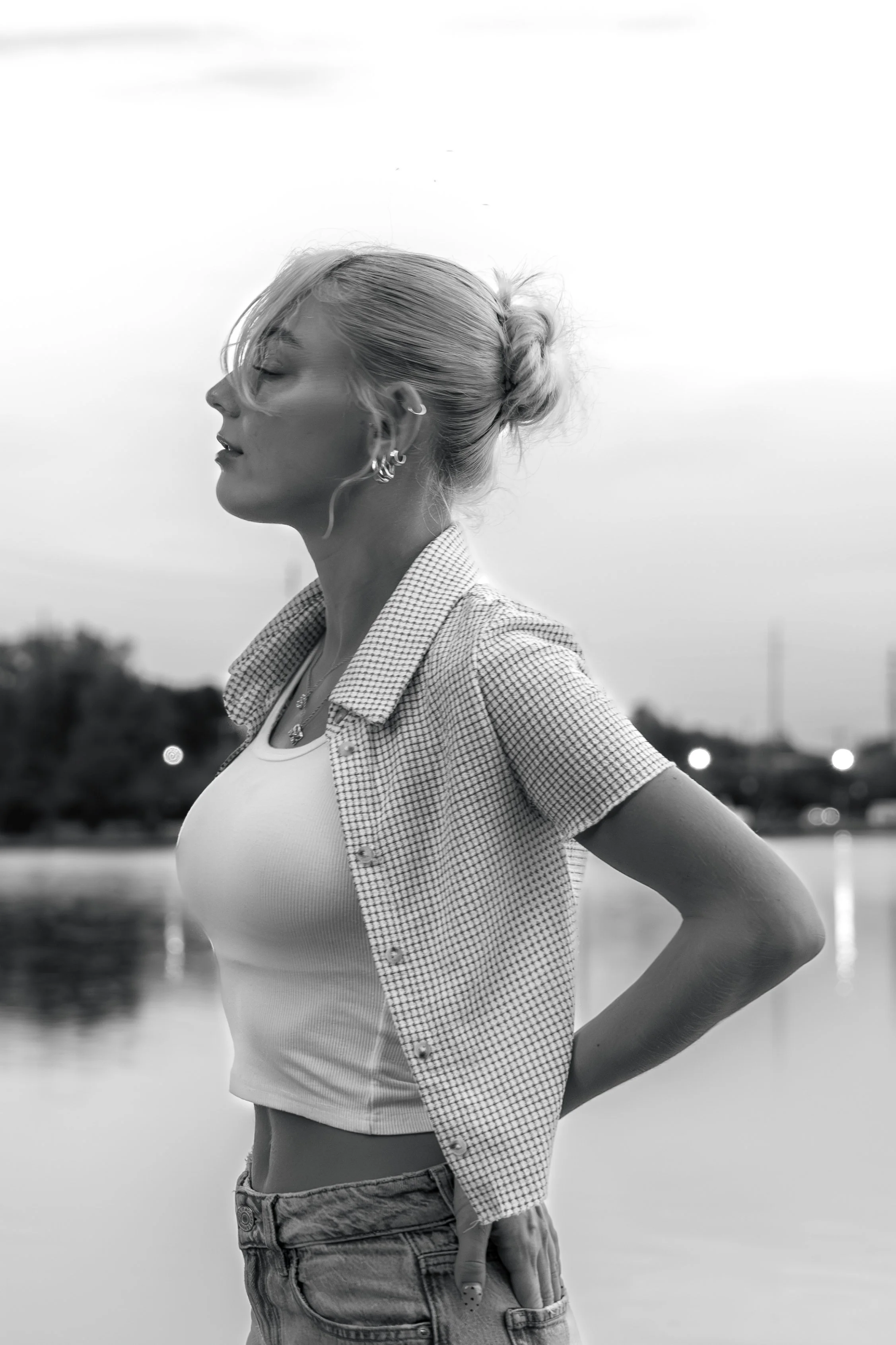 black-and-white side profile photo of a woman by the water in soft natural light