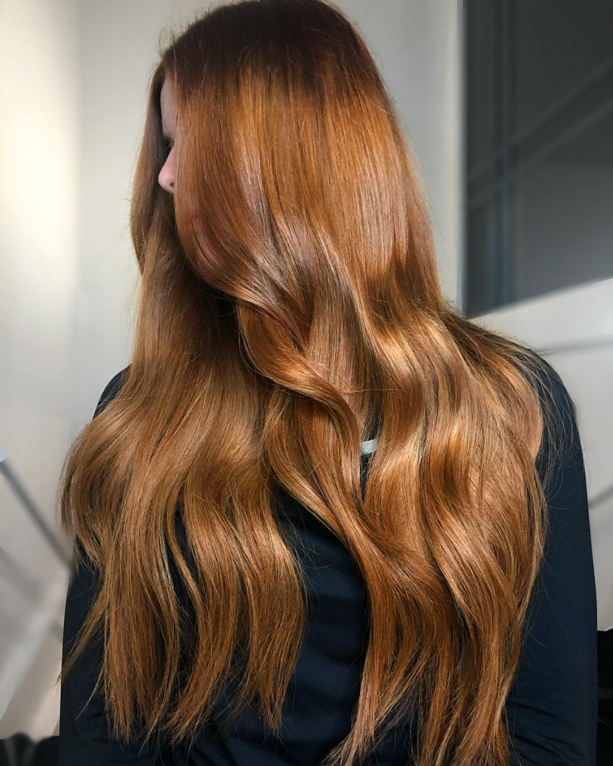 A woman with long, wavy, reddish-brown hair.