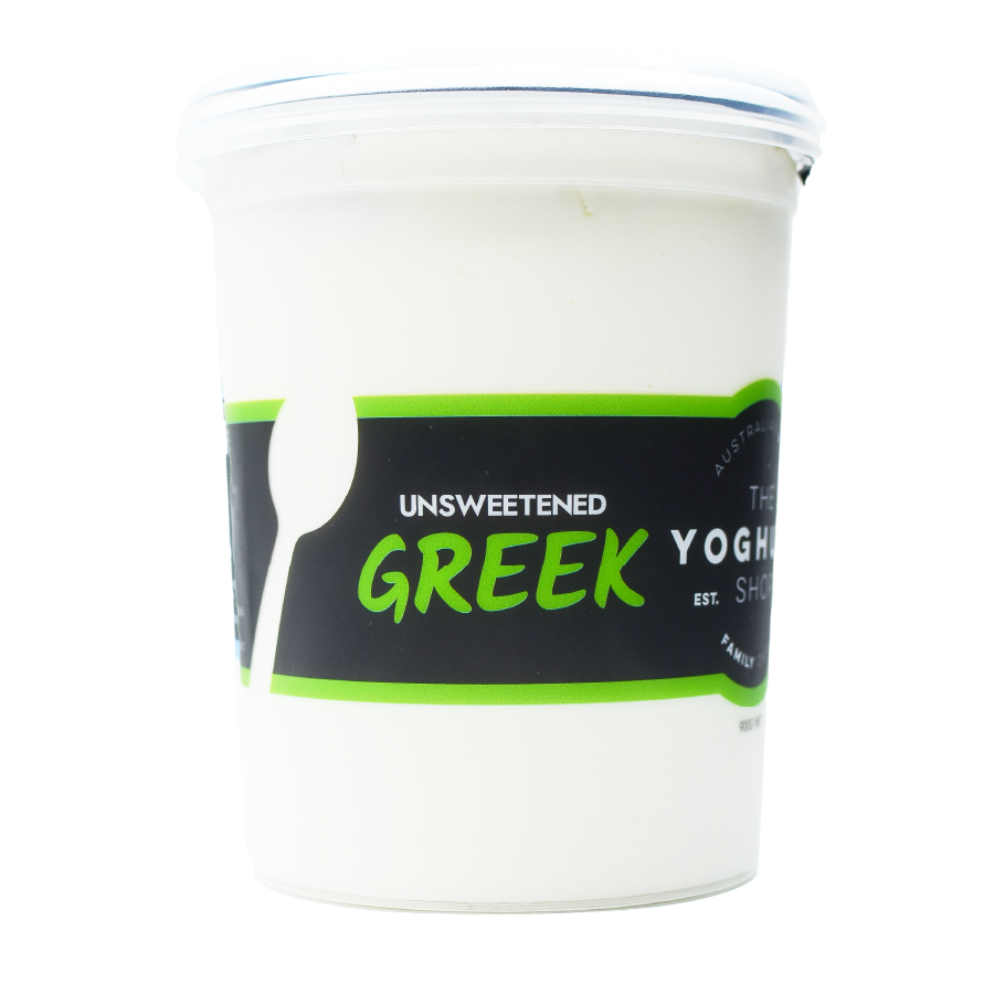 Side view of The Yoghurt Shop Unsweetened Greek yoghurt 900g tub, showing creamy white yoghurt filling the container and the prominent product label with green accents.