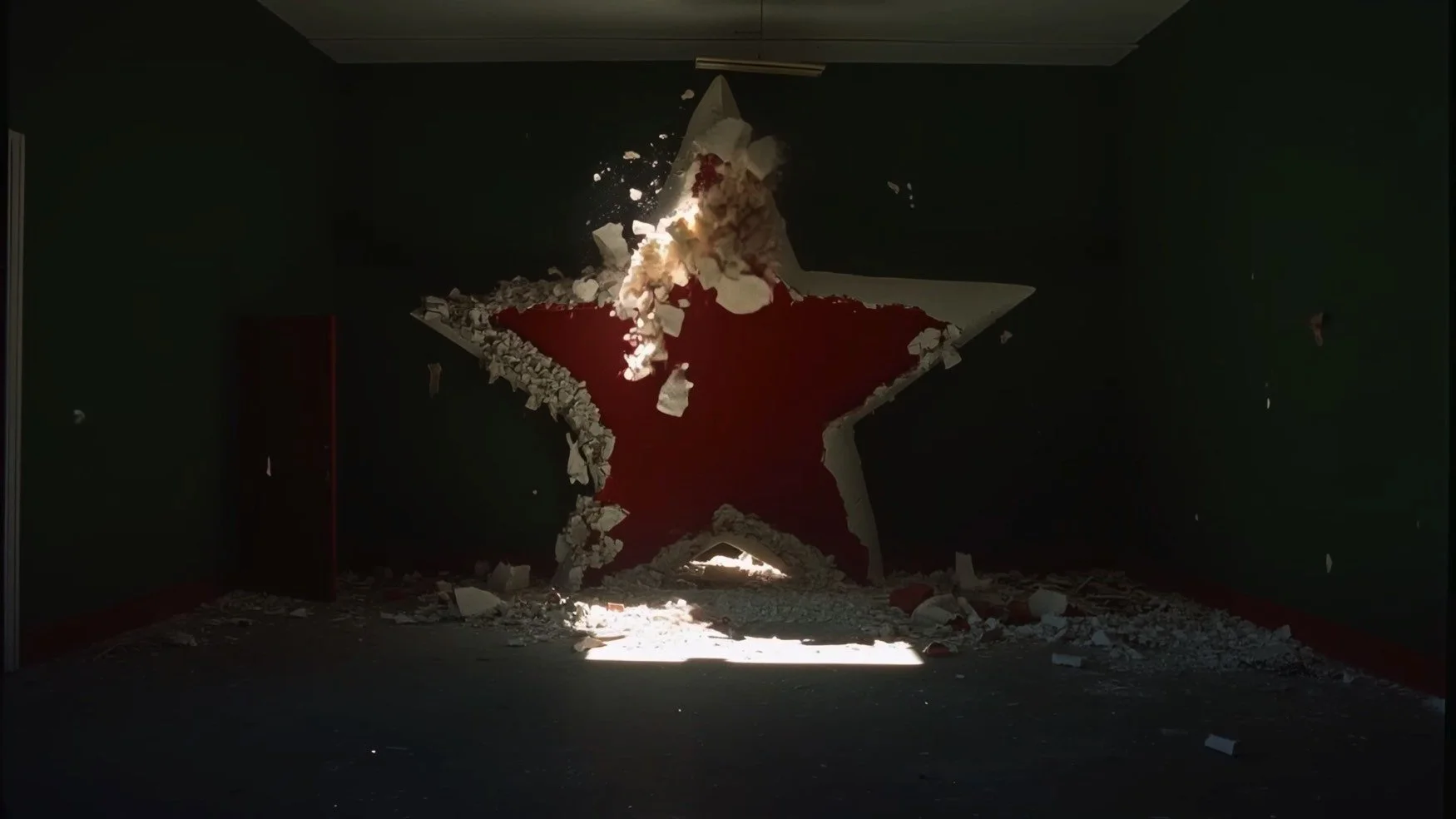 Exploding wall with a red star design, debris flying in the air, sunlight coming through a small opening near the floor.