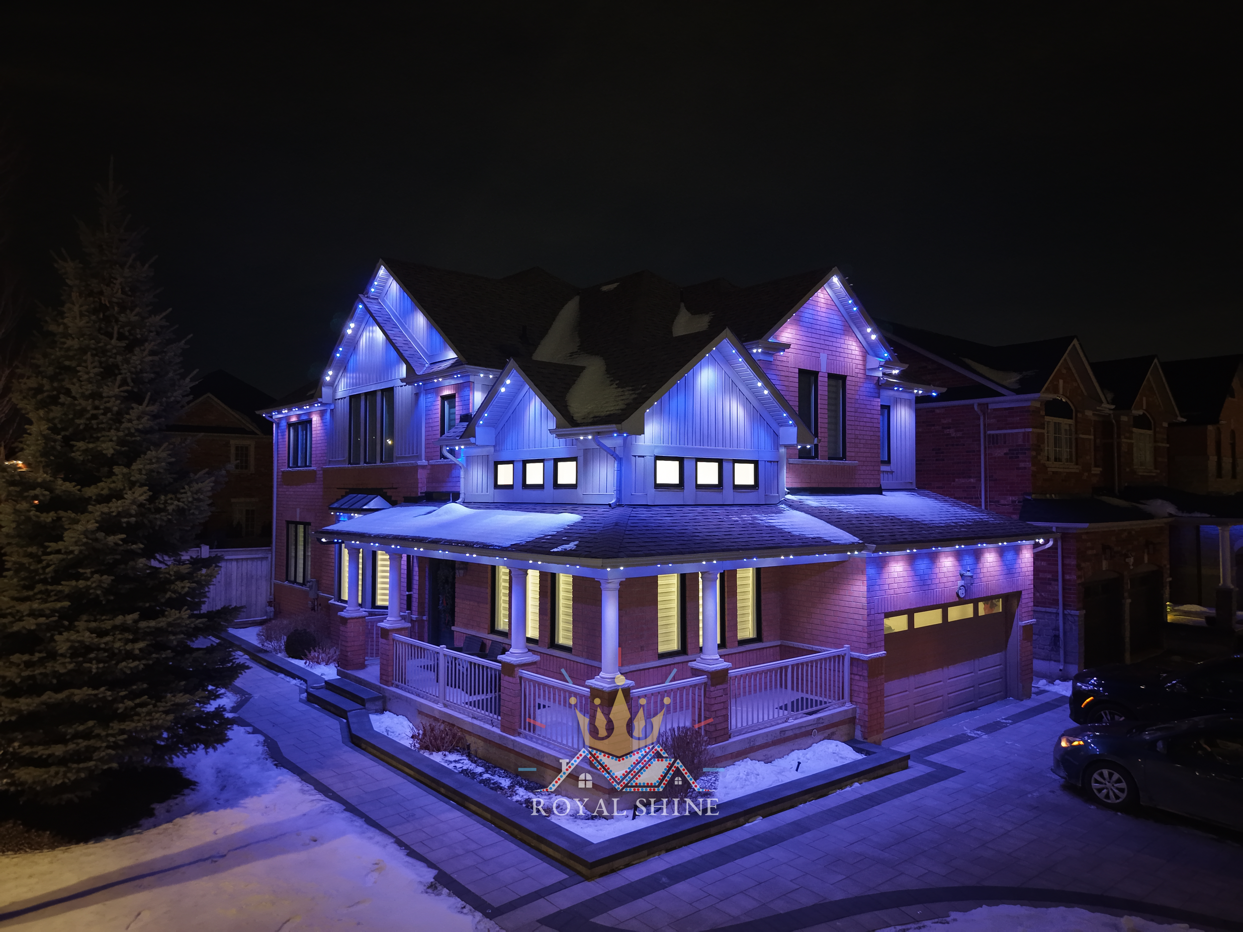 Two-story brick house at night with LED lights in red, white, and purple, branded "Royal Shine LED Lighting", captioned "Pattern: Toronto Raptors".