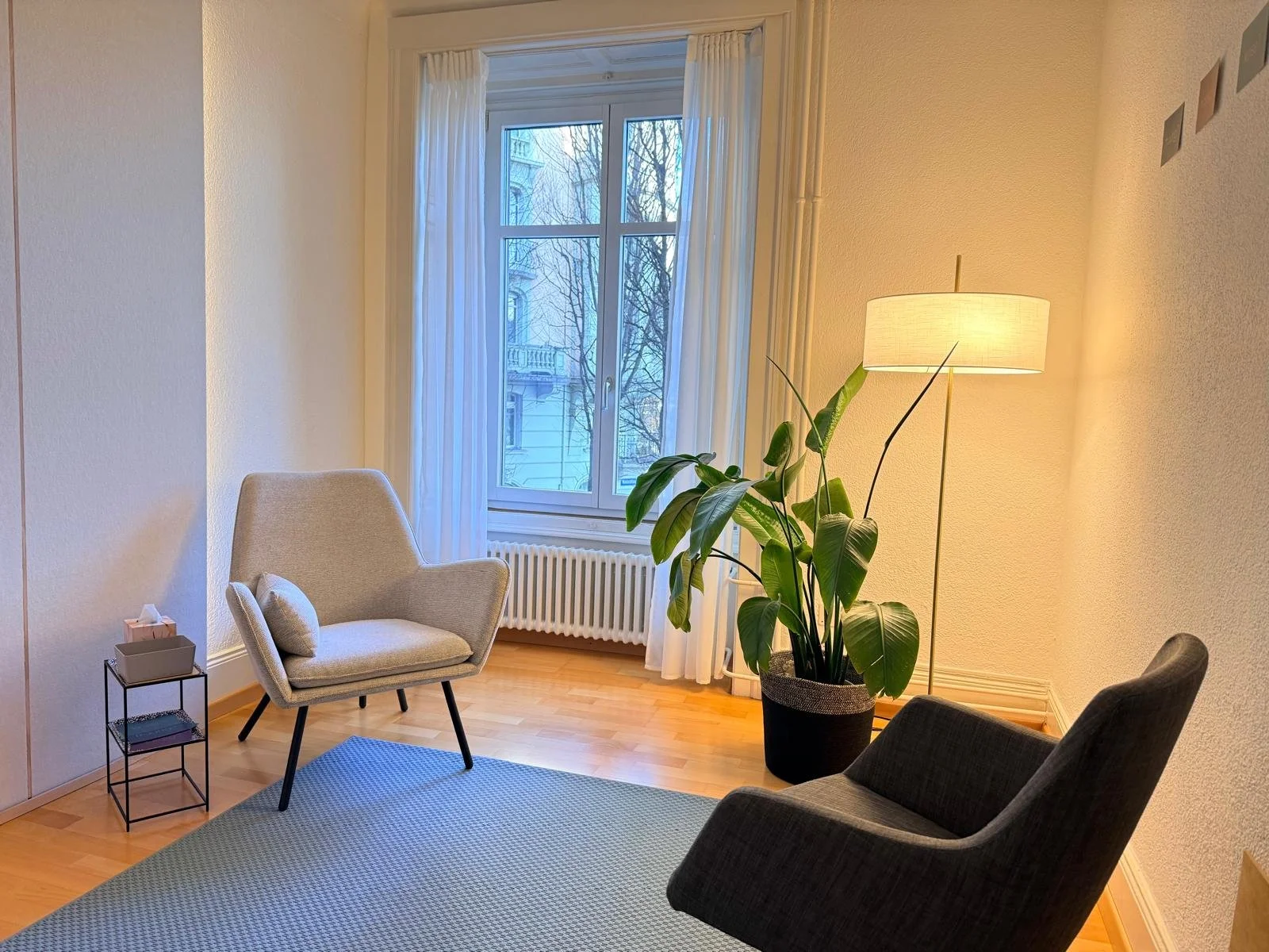 Gemütliches Beratungszimmer mit zwei bequemen Sesseln in warmer, einladender Atmosphäre für vertrauensvolle psychologische Gespräche.