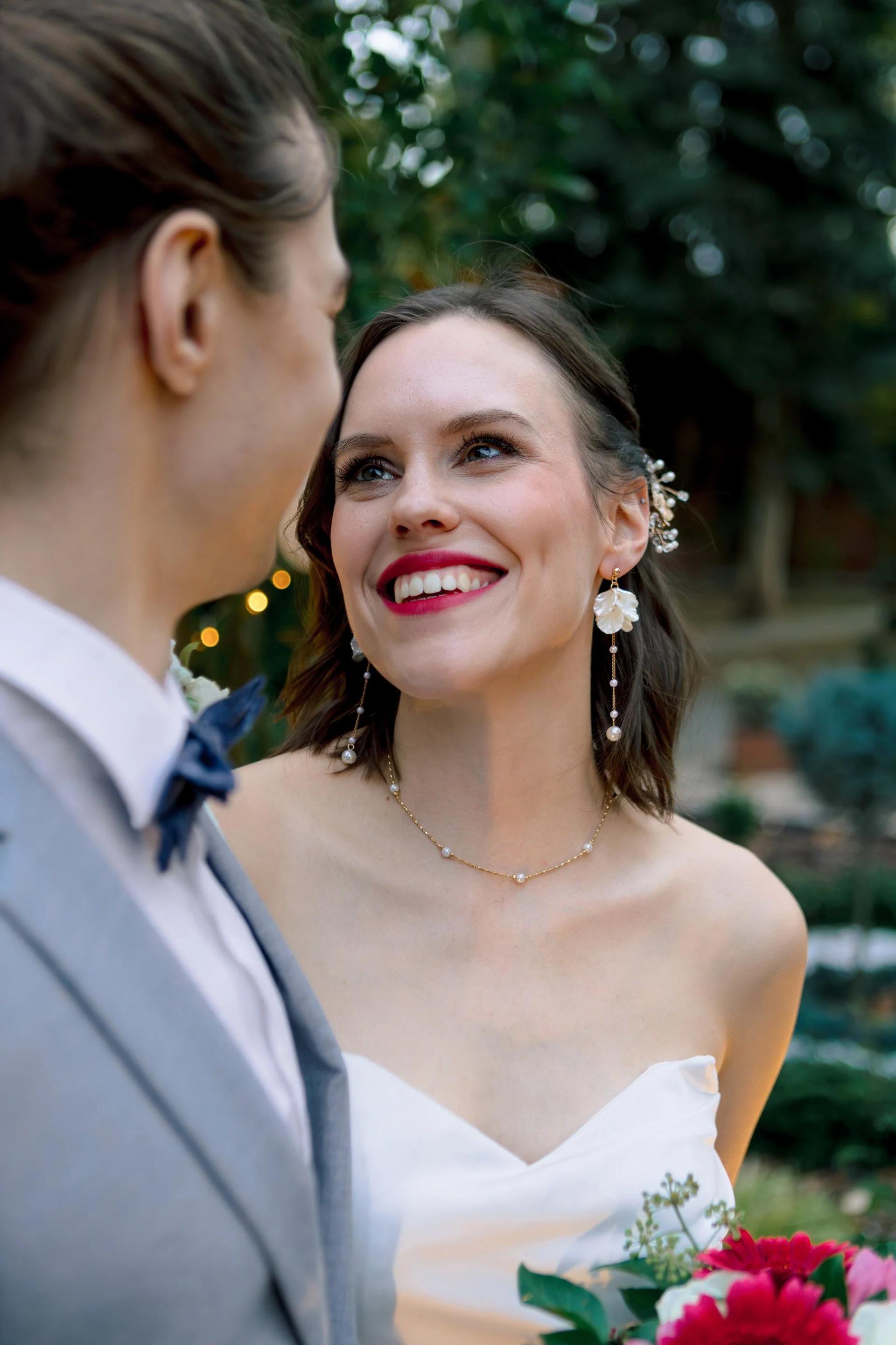 A menyasszony a vőlegényre mosolyog és keresztezi egymást a tekintetük, friss házasok. Kéri Levente esküvői fotó