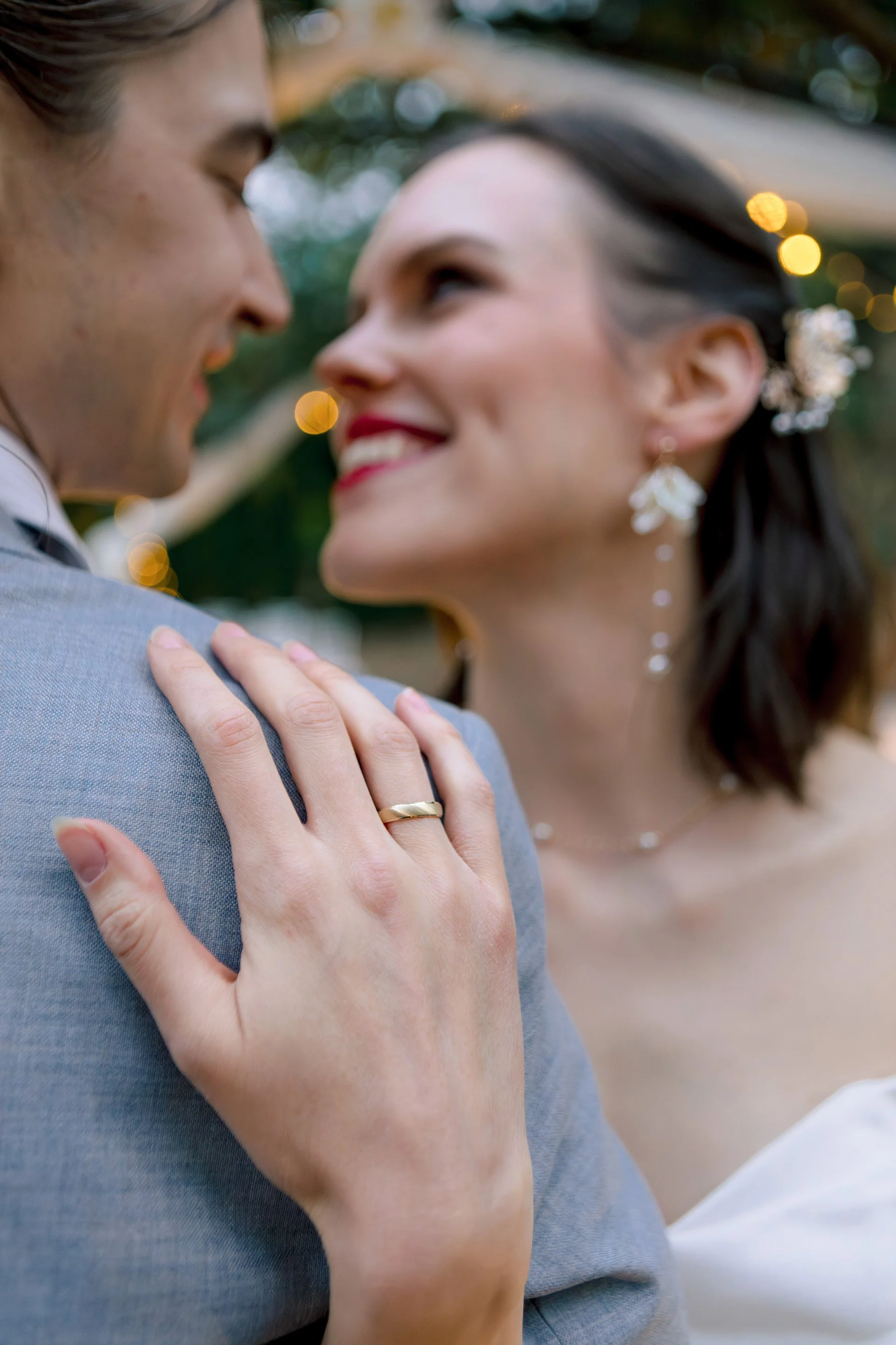 Közeli kreatív fotó az esküvő napján a karikagyűrűről és a párról. Természetes színek és pillanatok. Kéri Levente esküvői fotó