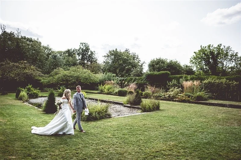Colour photo of the bride and groom walking back from their wedding ceremony. Kent wedding photography at Bore Place - Matt Rock