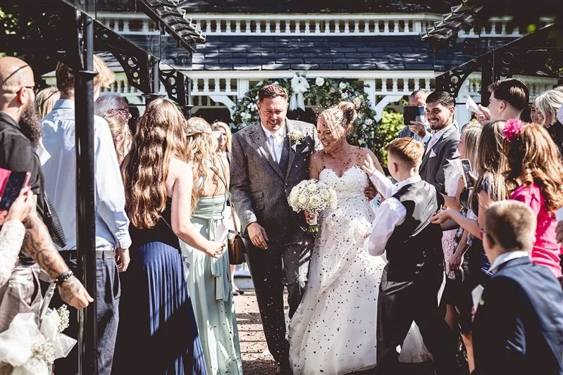 colour photo of the bride and groom and confetti at The Old Kent Barn- Kent