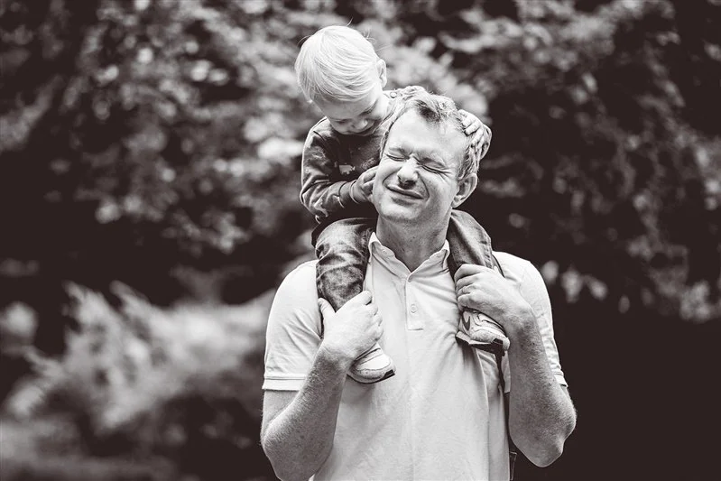 Black & White photo from a family shoot of a father with his son on his shoulders