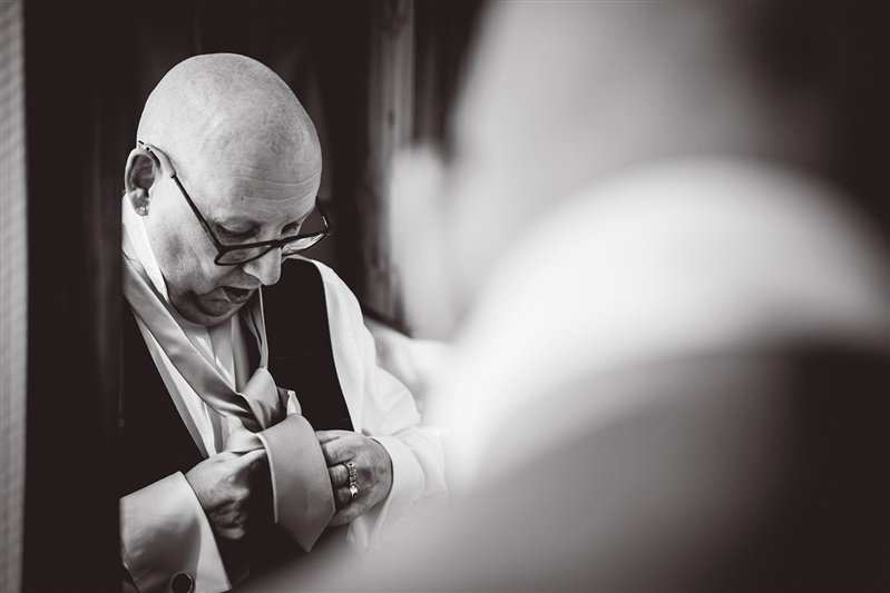 fATHER OF THE BRIDE PUTTING HIS TIE ON IN THE MIRROR