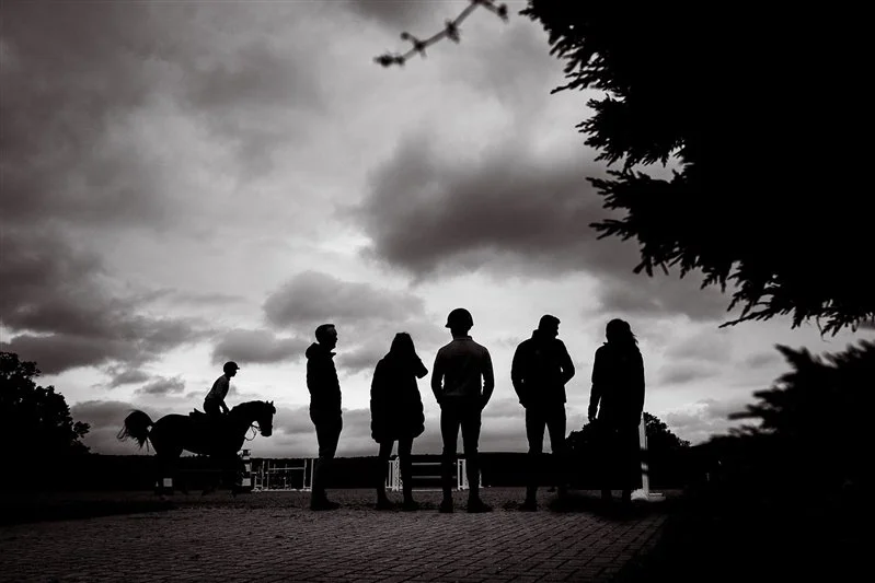 Black & white silhouette Commercial equestrian shoot - Rider and horse parading around the show ground with onlookers looking to buy a horse stables - UK 