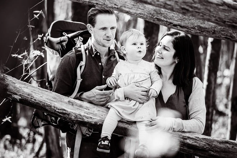 Young family by a tree in the woods