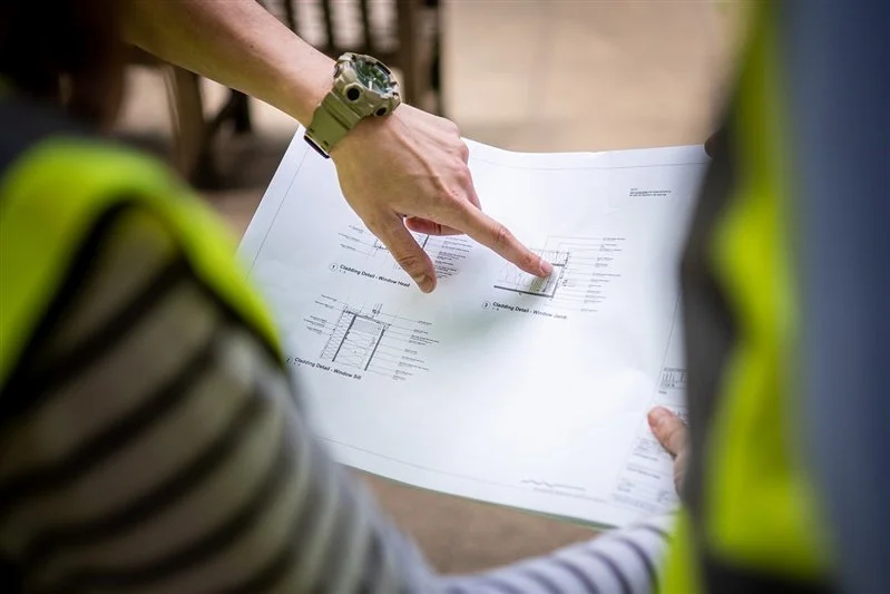 Commercial shoot for a London based surveyors - photo of an office environment - someone pointing to a drawing of plans