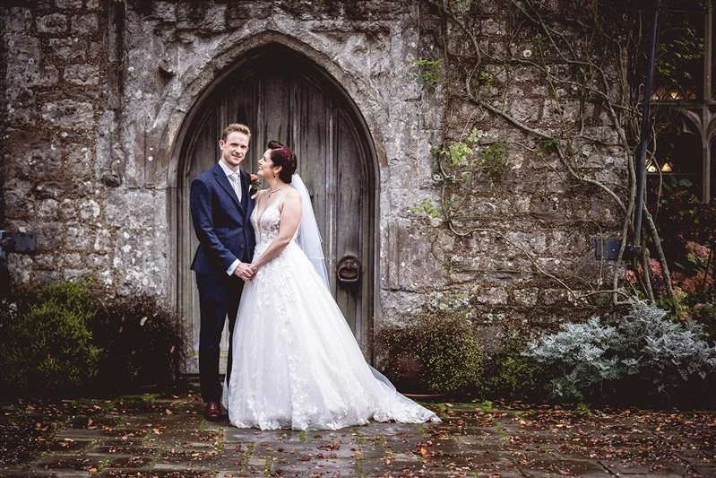 Colour photo in Autumn of the Bride and groom portrait standing outside in fron of the castle door - Lympne Castle in Kent