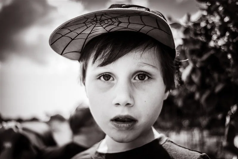 Black & White photo of a boy with a Spiderman baseball cap on