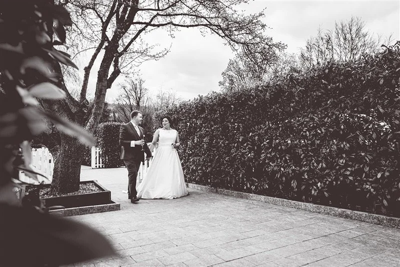 Black & white photo of the bride and groom walking back to their wedding receptionKent wedding photography at The Darenth - Matt Rock