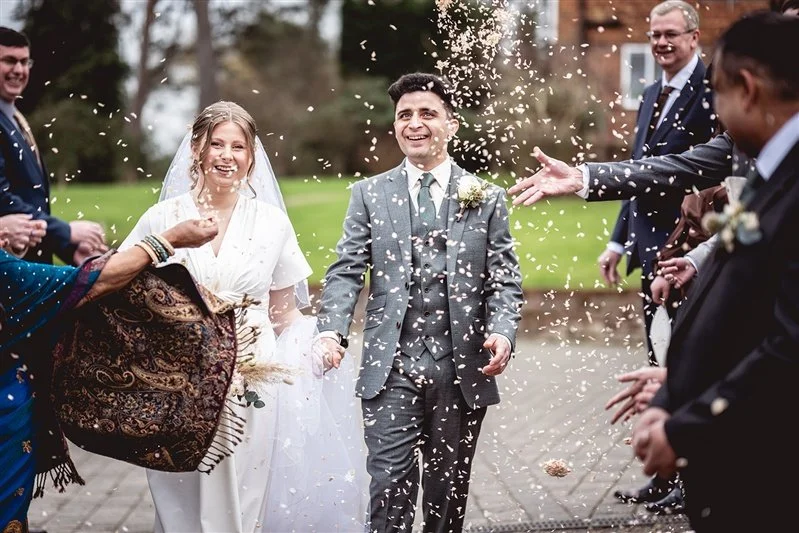 colour photo of the bride and groom and confetti at The Oak Barn, Frame Farm - Kent